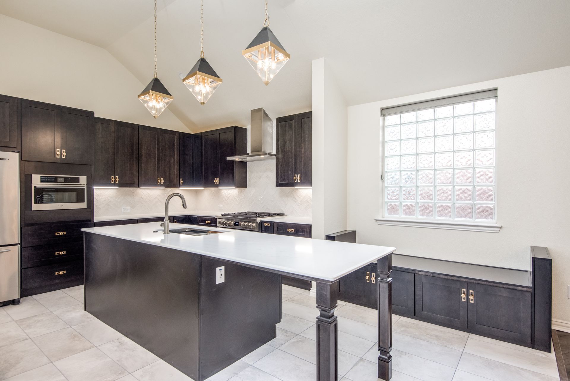 A kitchen with black cabinets and white counter tops