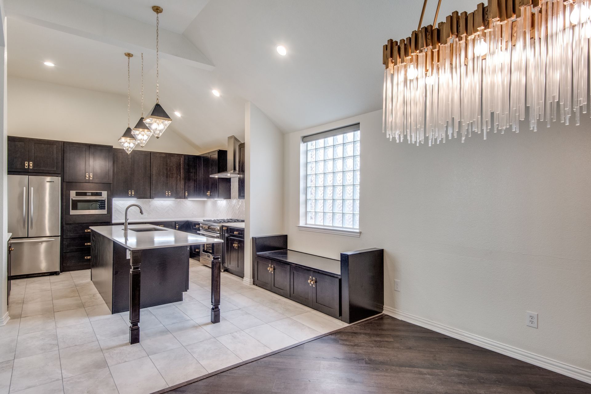 A kitchen and dining room in a house with a large chandelier hanging from the ceiling.