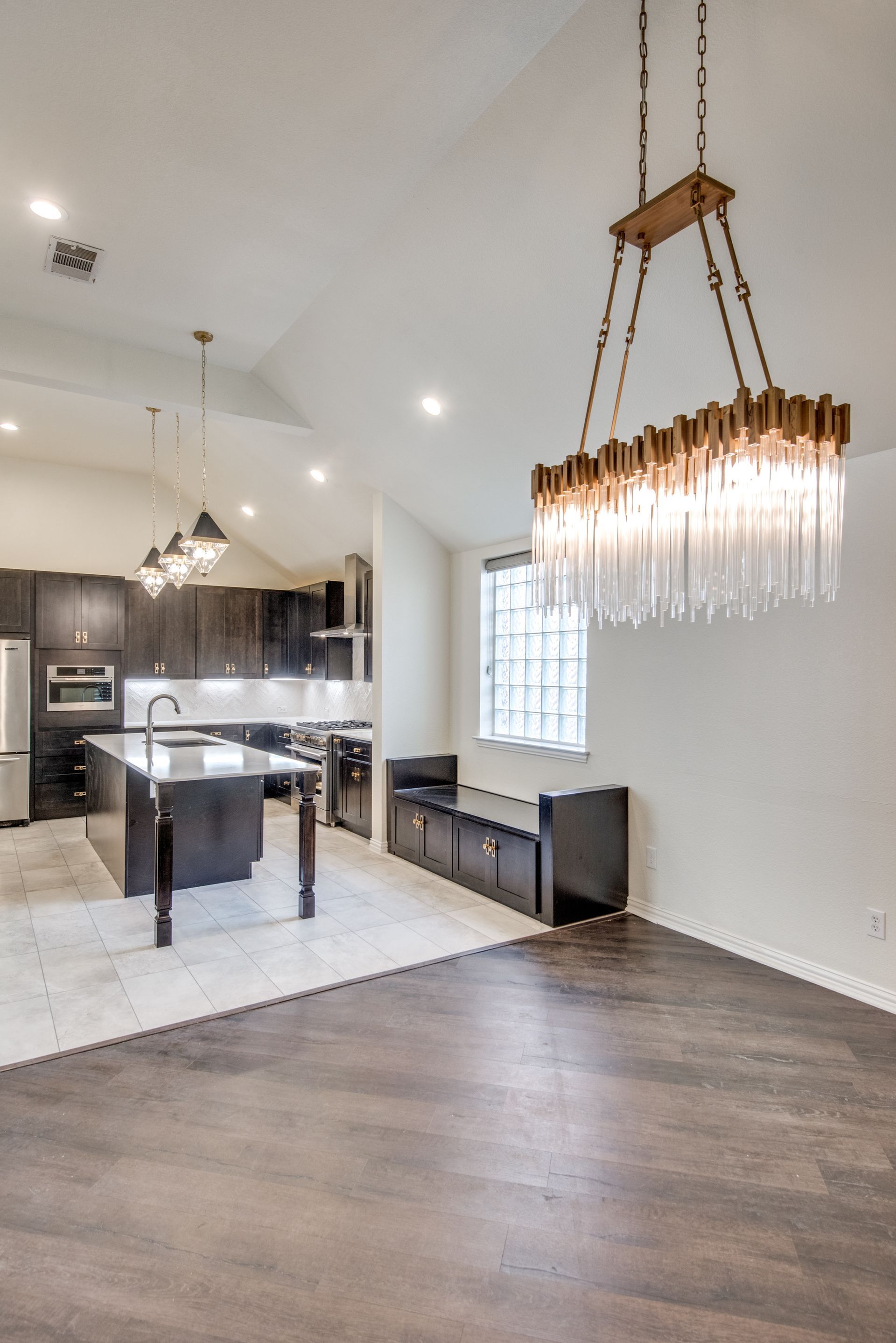 A kitchen and dining room in a house with a chandelier hanging from the ceiling.