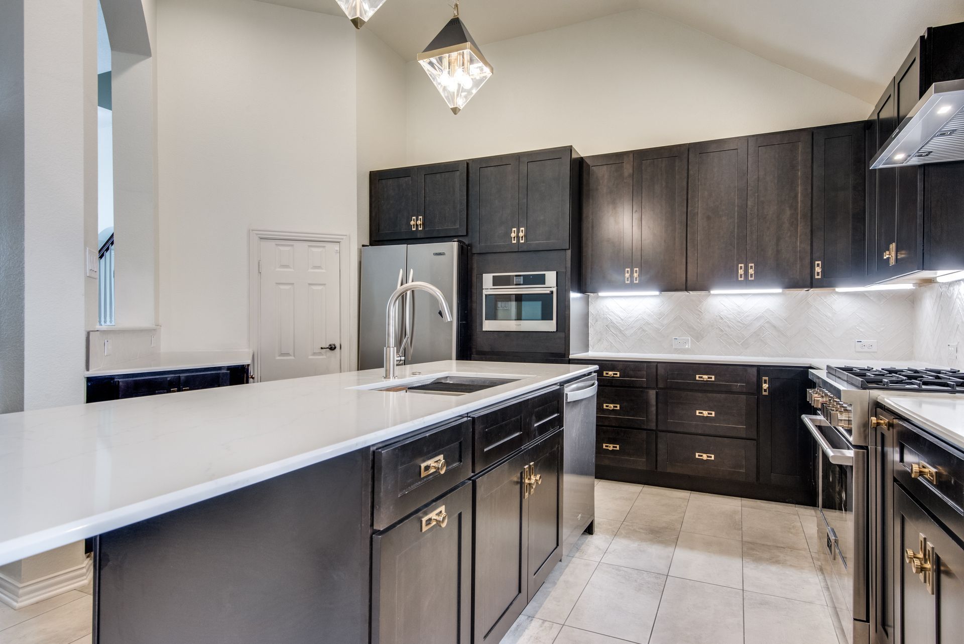 A kitchen with black cabinets and stainless steel appliances