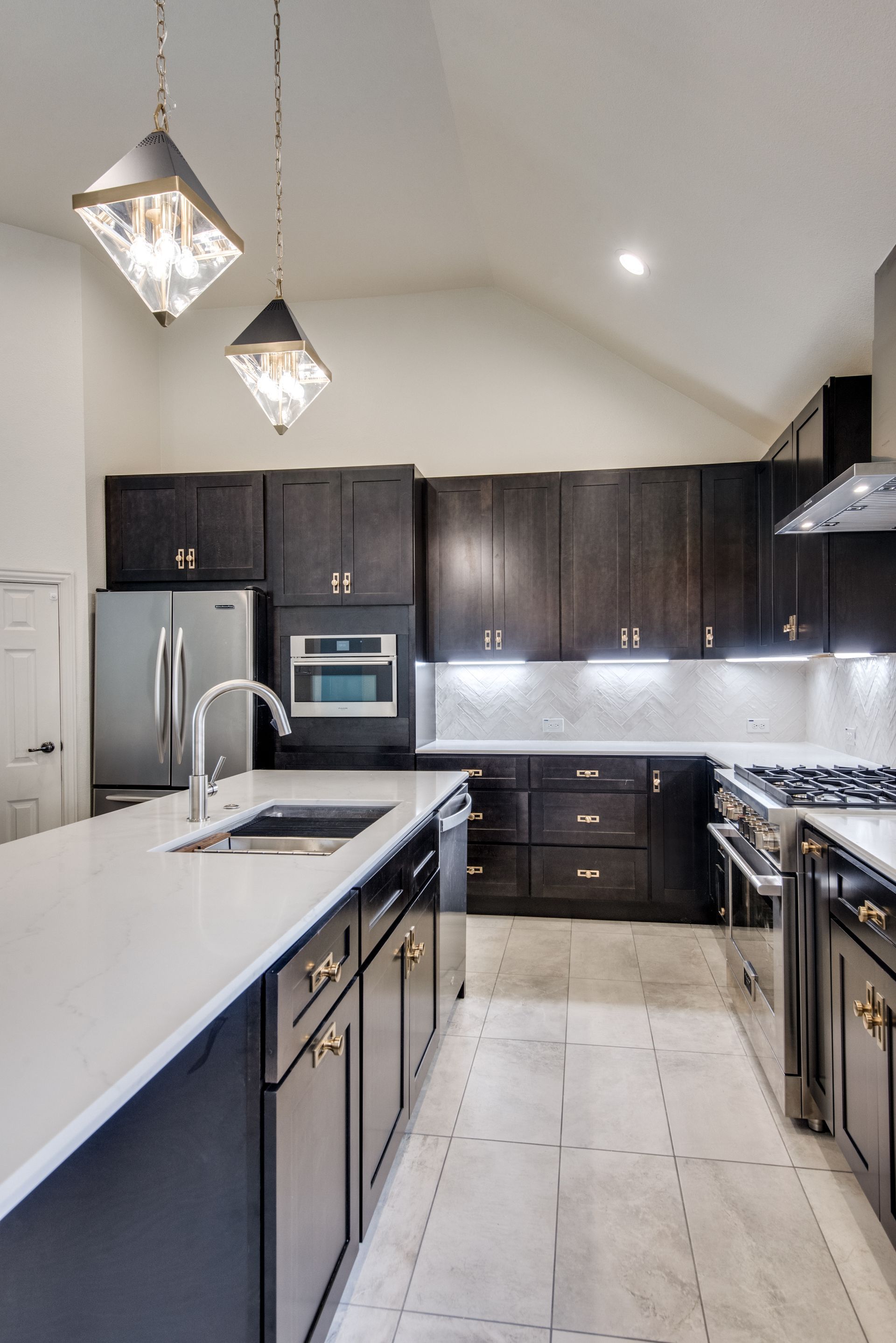 A kitchen with stainless steel appliances and black cabinets