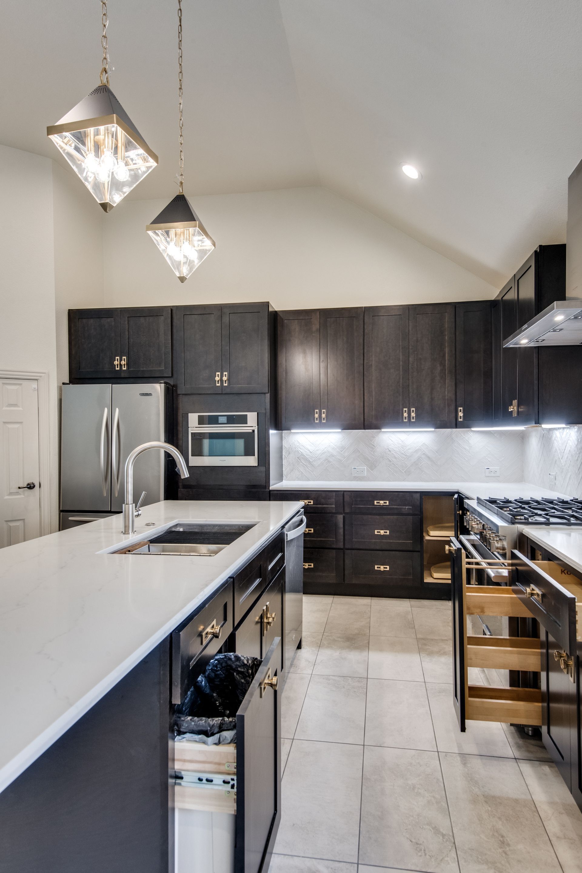A kitchen with stainless steel appliances and black cabinets