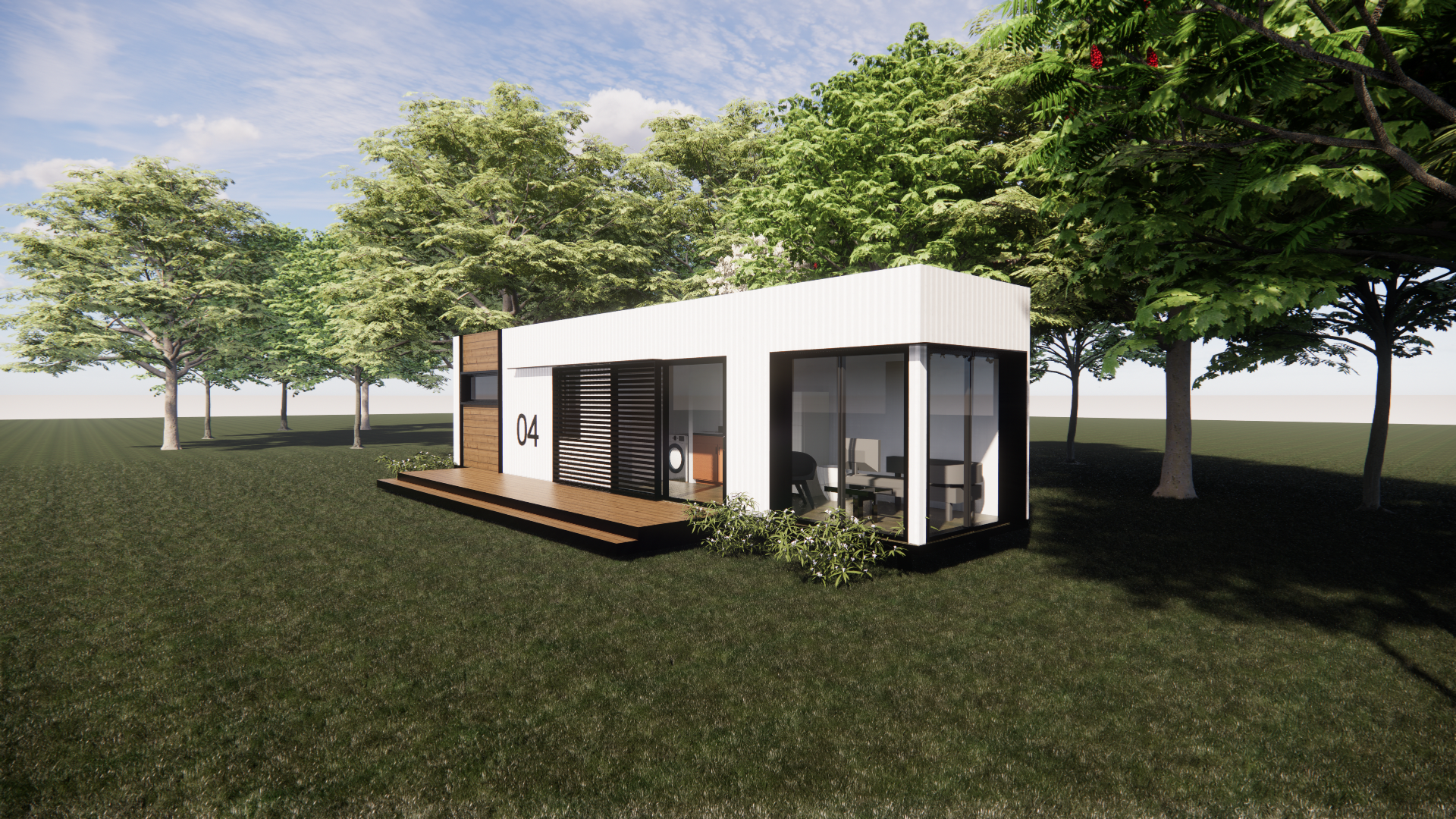 A small white house is sitting in the middle of a grassy field surrounded by trees.