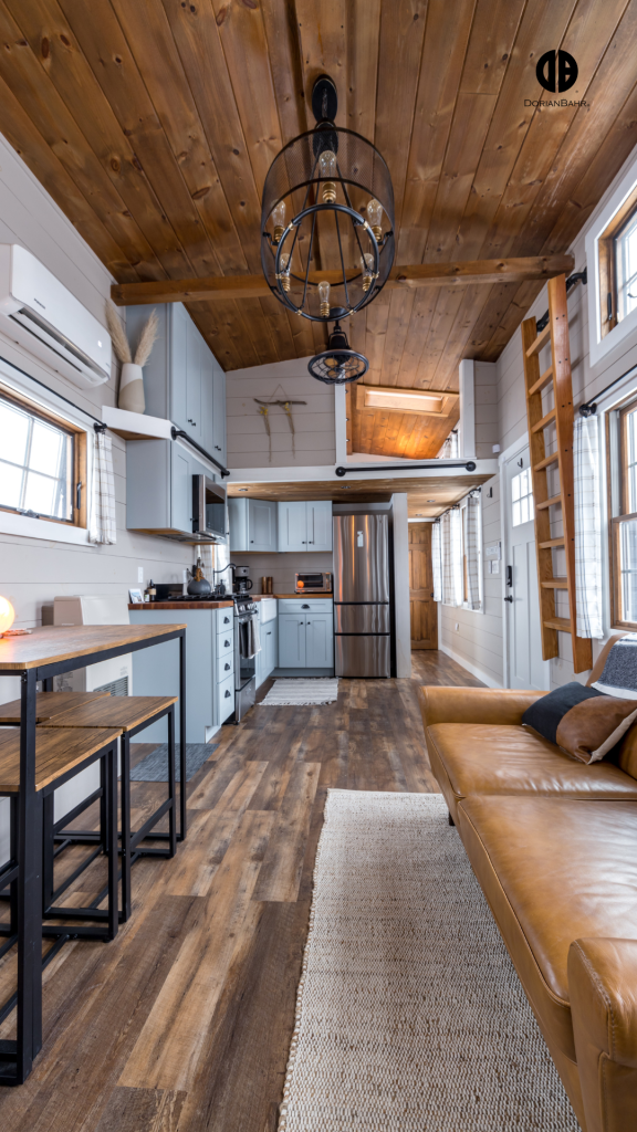 A tiny home living room with a couch , table and chairs and a kitchen.