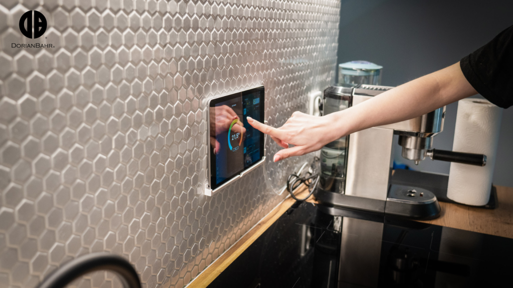 A person is touching a smarthome automation tablet on a kitchen backsplash.