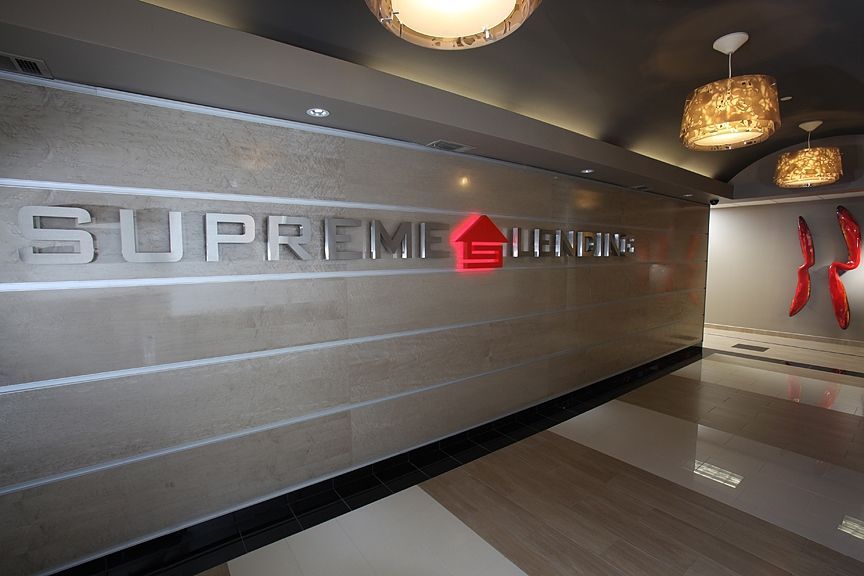 A woman in a wheelchair is standing in front of a neighborhood rendering.