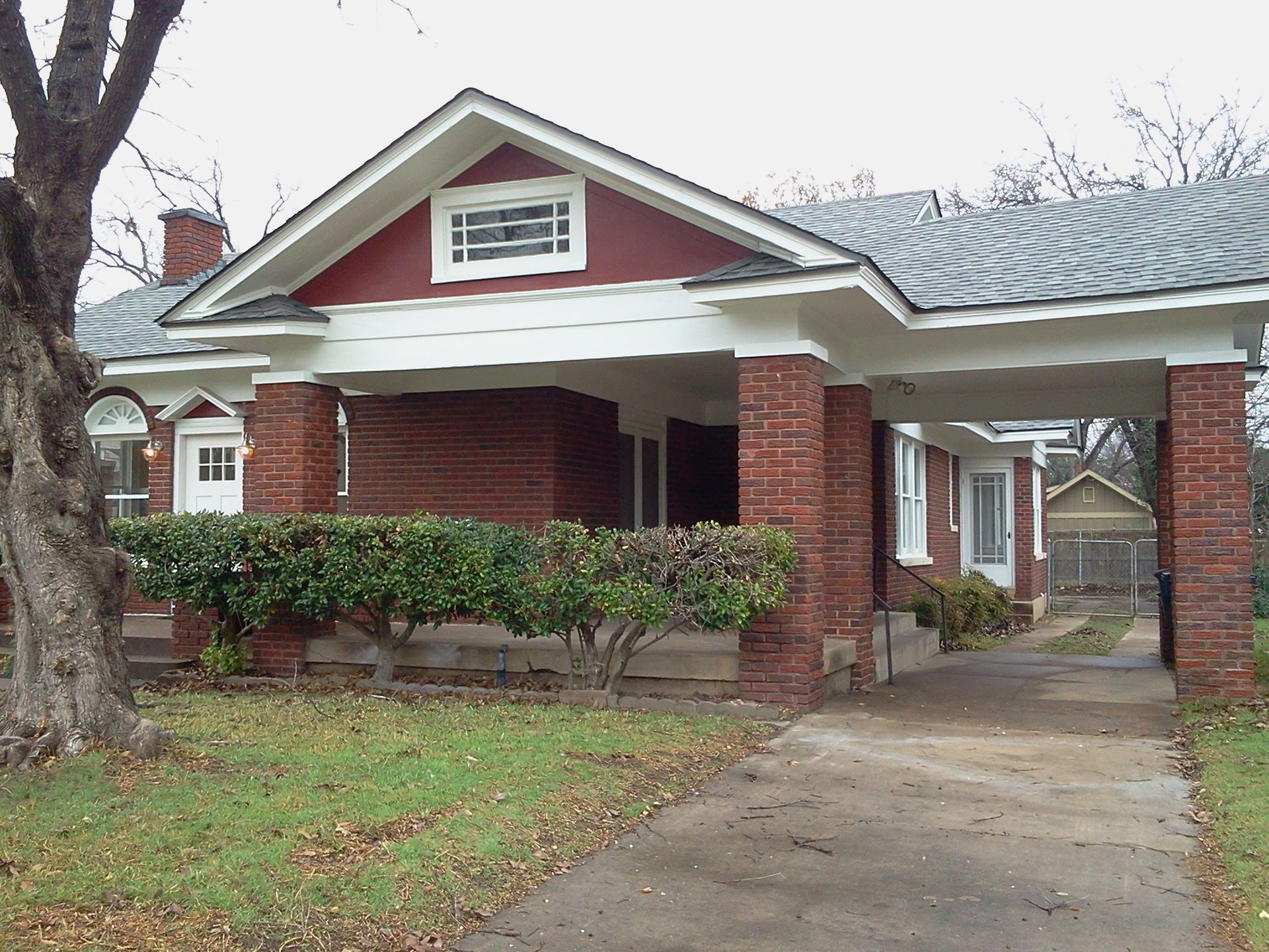 A brick house with a driveway leading to it