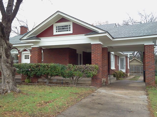 A brick house with a driveway leading to it