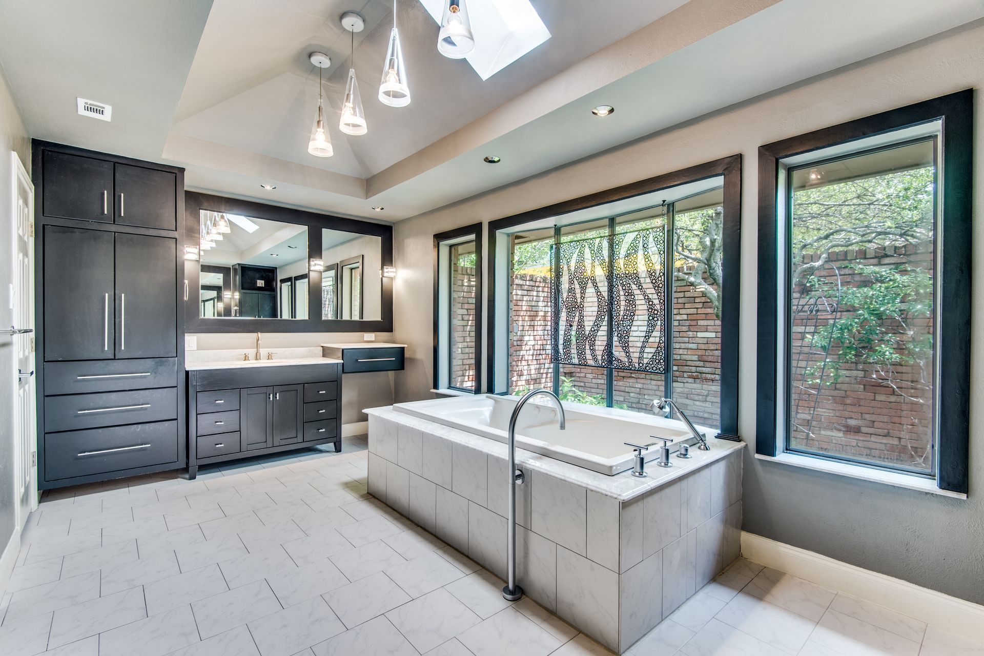 A Plano home remodel bathroom with a large tub and lots of windows