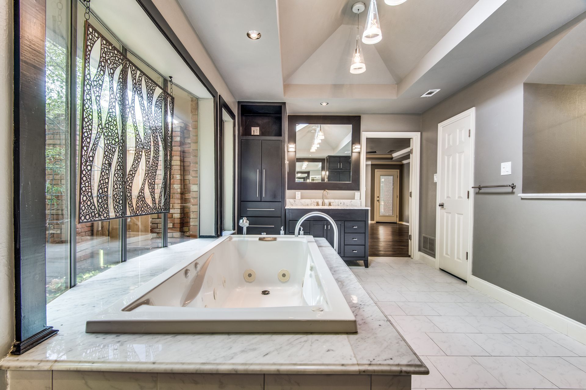 A large bathroom remodel with a jacuzzi tub and a large window.
