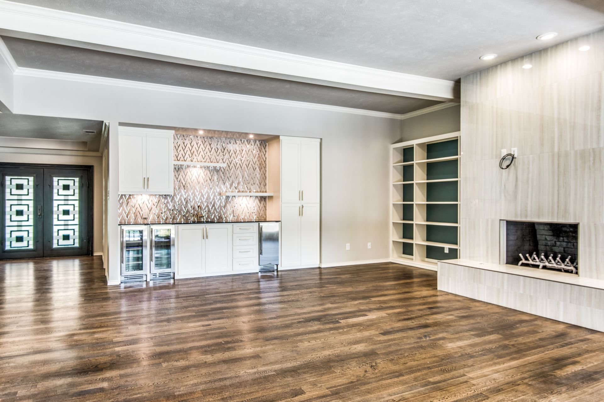 An empty living room with hardwood floors and a fireplace.