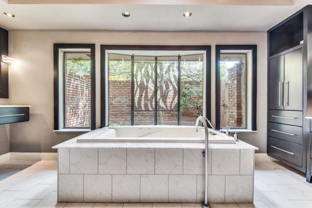 A large bathtub in a bathroom with a lot of windows