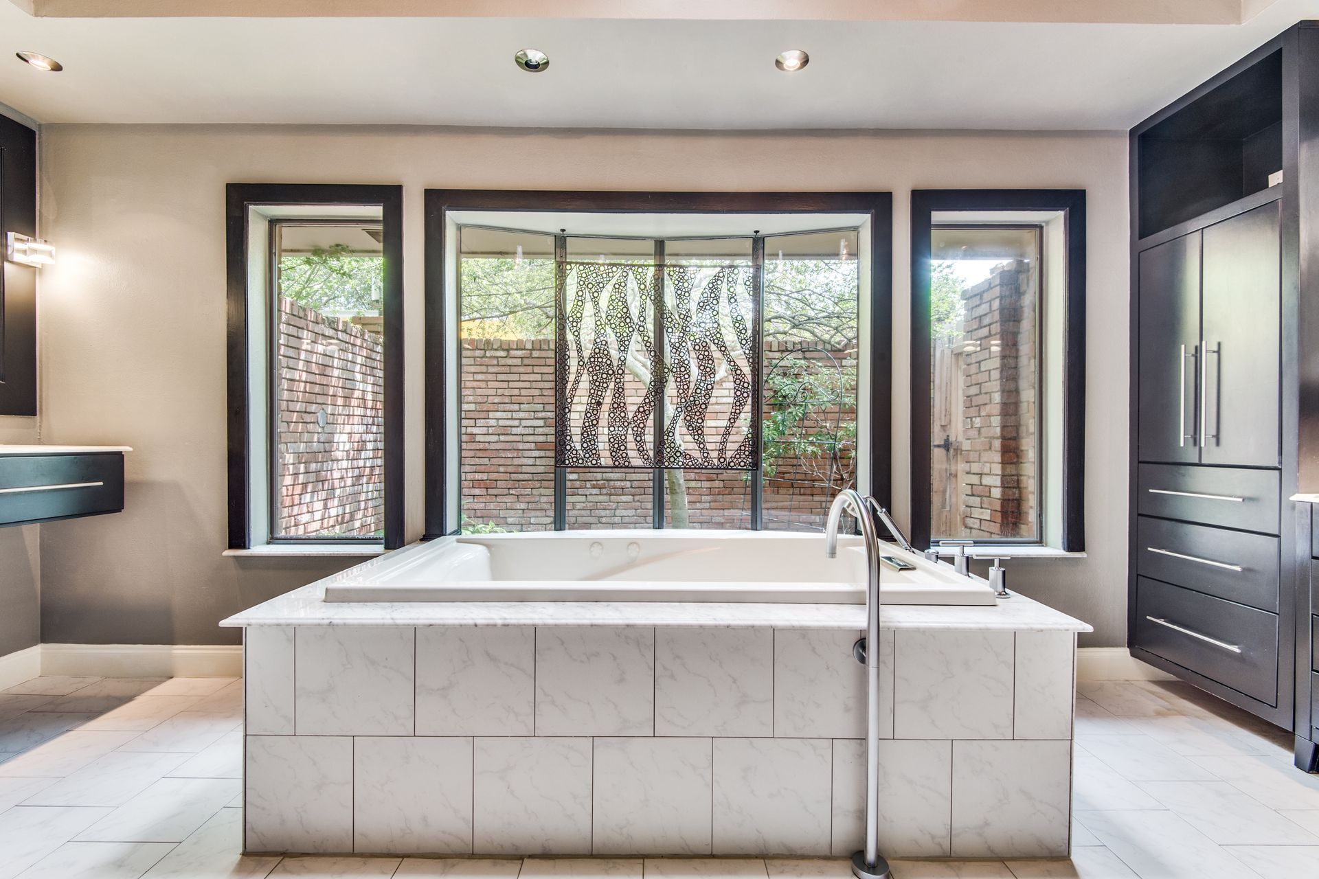 A large bathtub in a bathroom remodel with a lot of windows