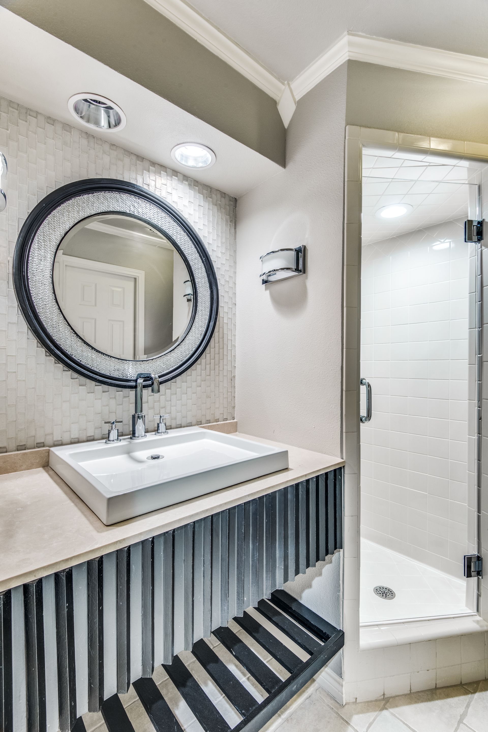 A bathroom remodel with a sink , mirror and shower.