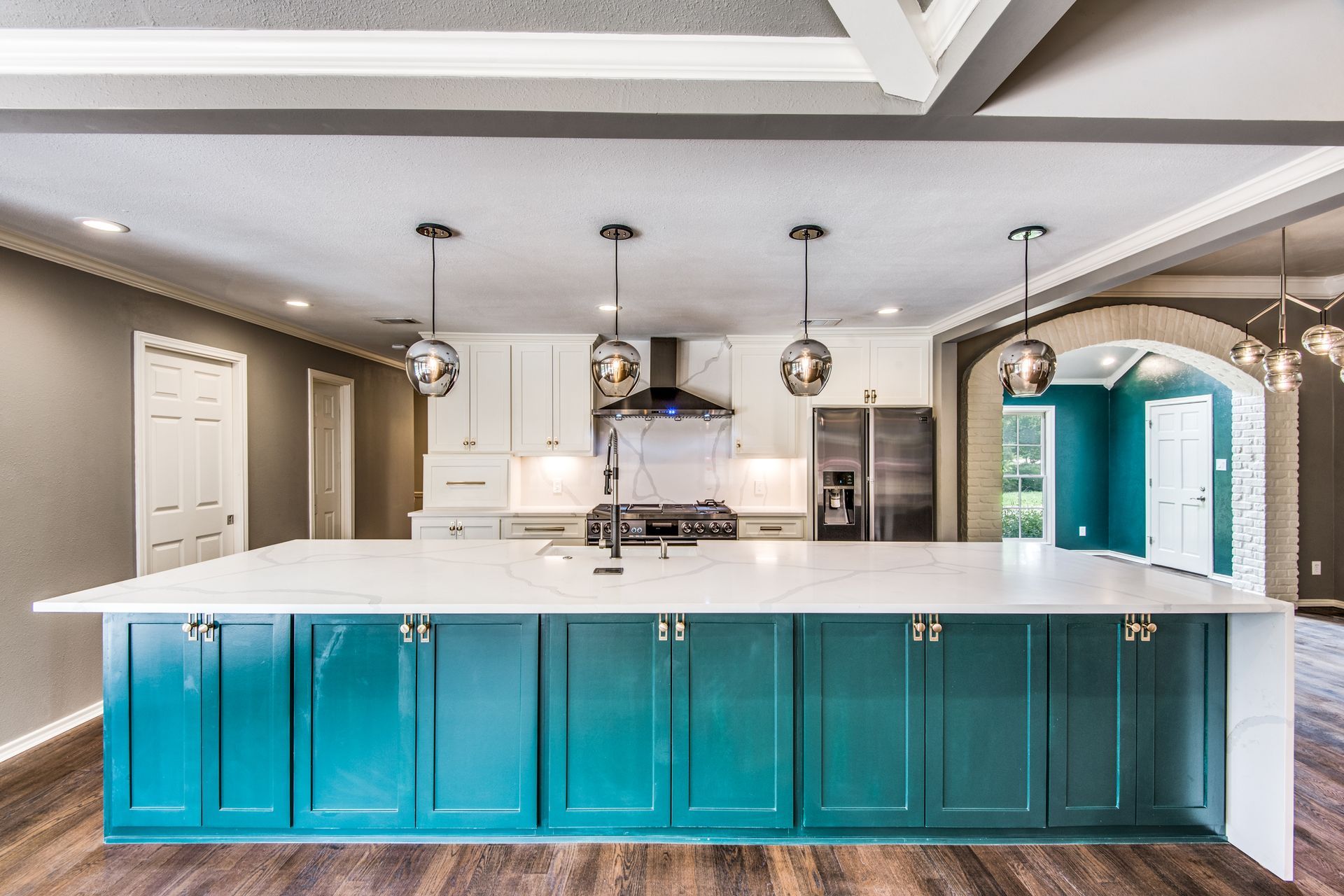 A kitchen with blue cabinets and white counter tops.