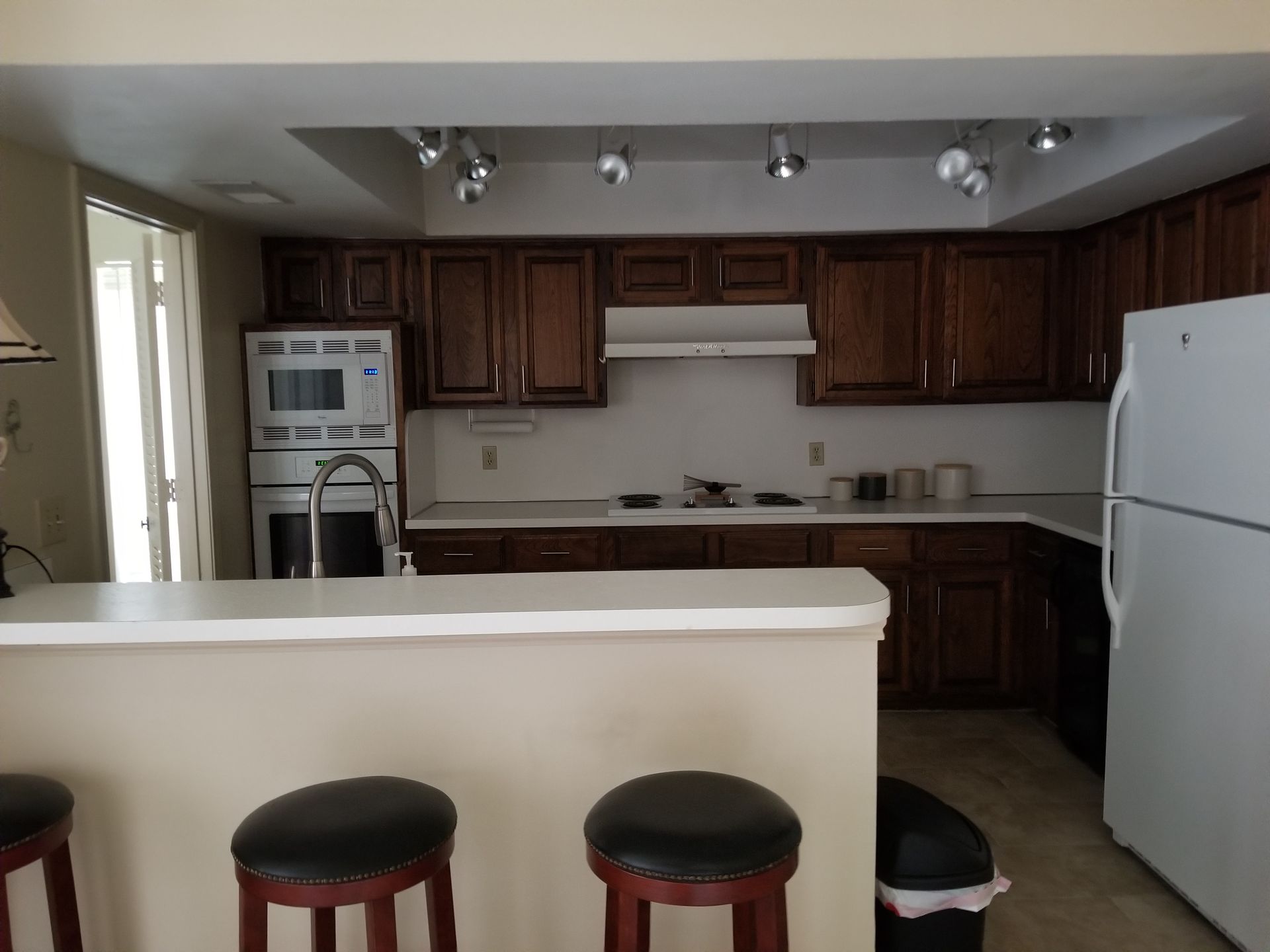 A kitchen with brown cabinets and a white refrigerator