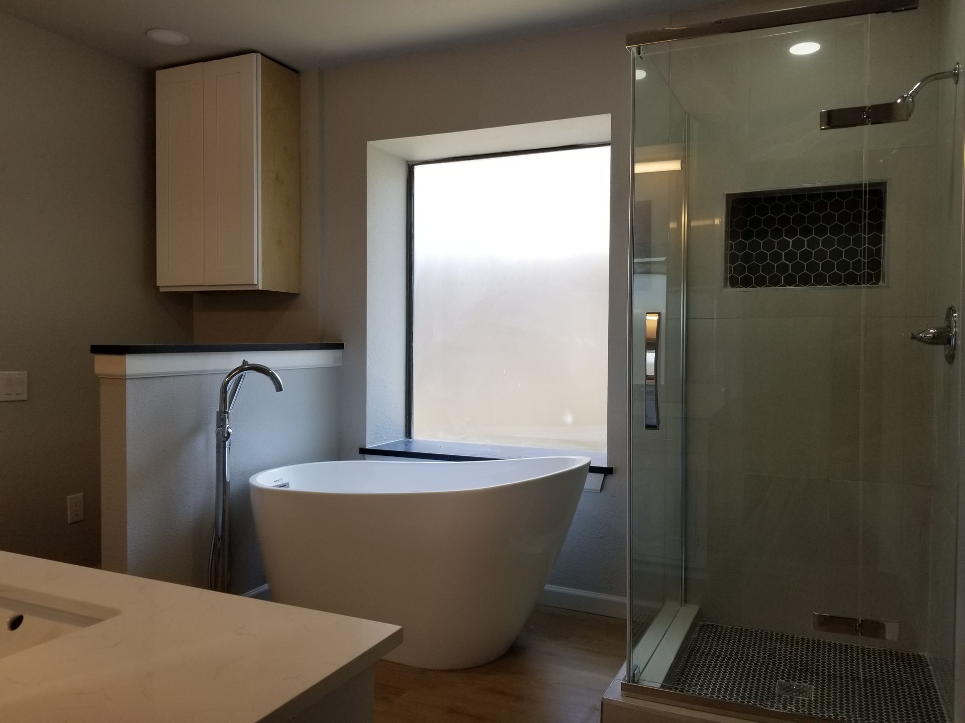 A bathroom remodel with a tub , sink , and shower.