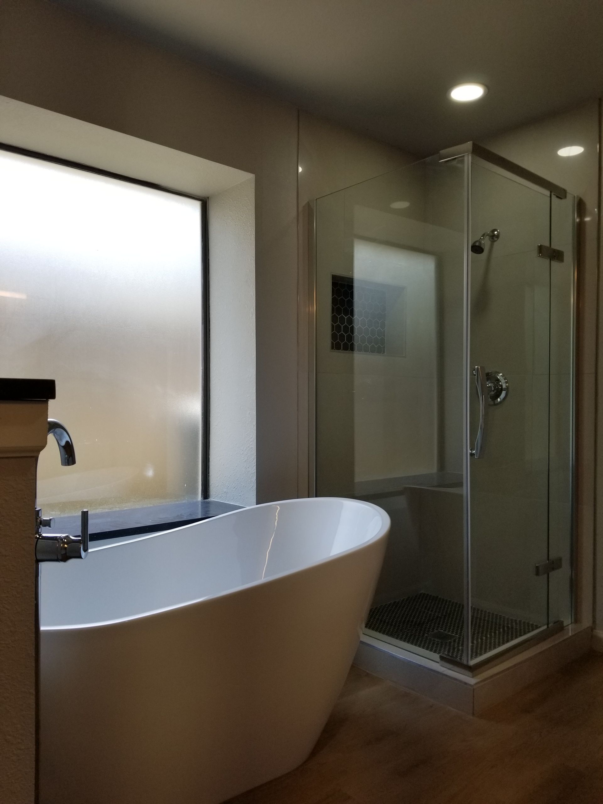A bathroom remodel with a bathtub and a shower stall