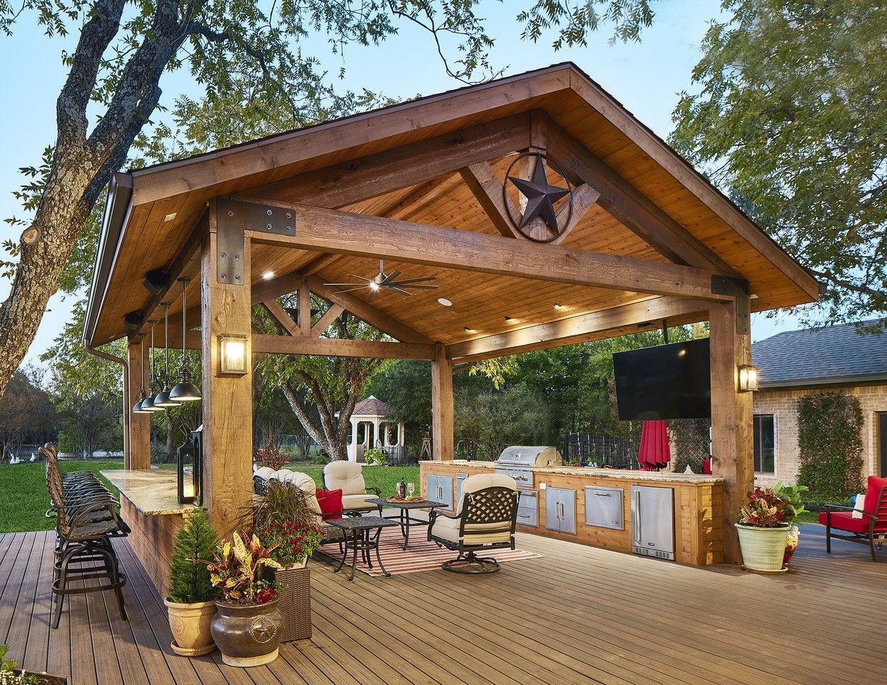 A large wooden pavilion with a texas star on the roof