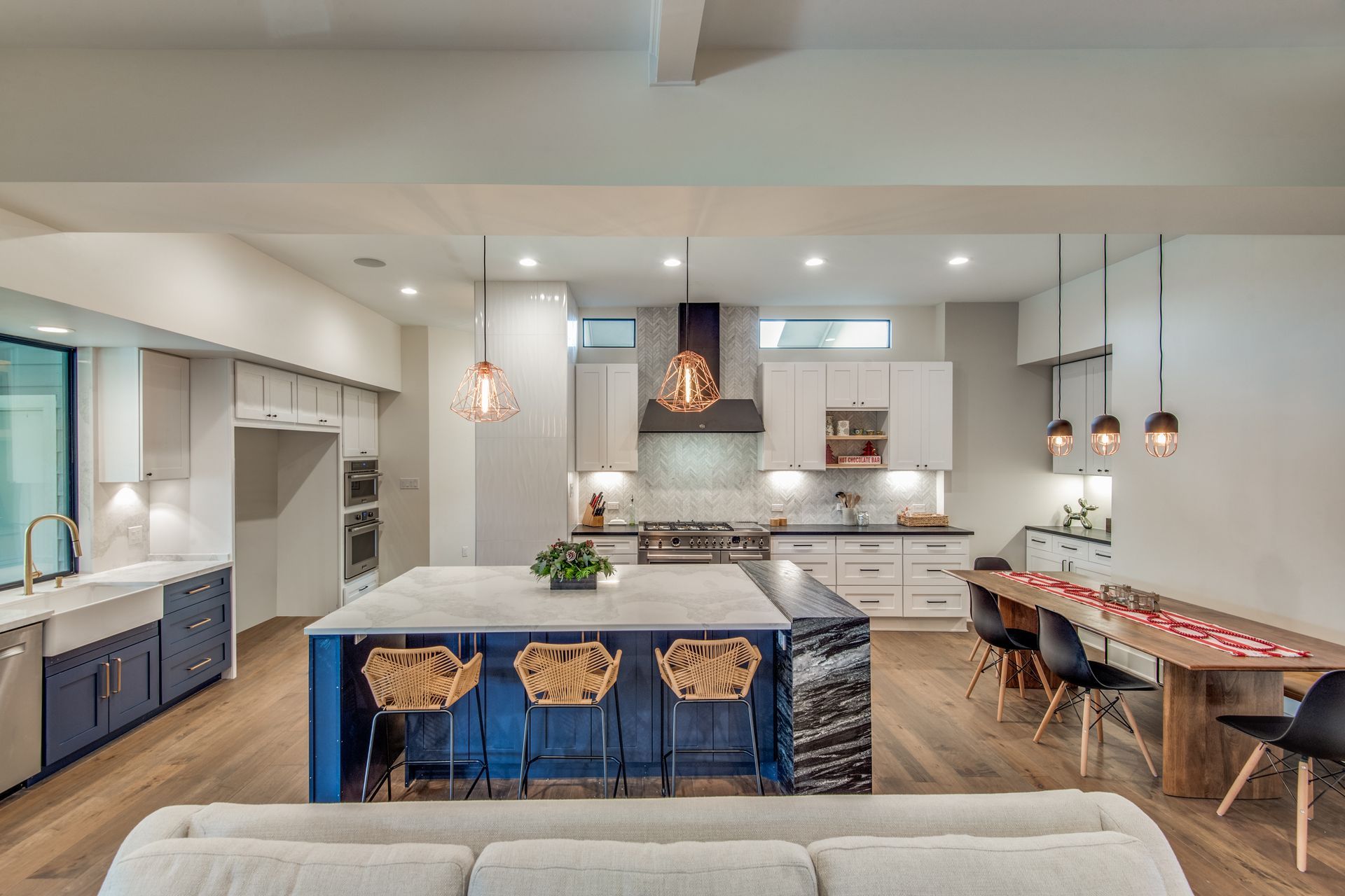 A kitchen and dining room in a house with a large island in the middle.