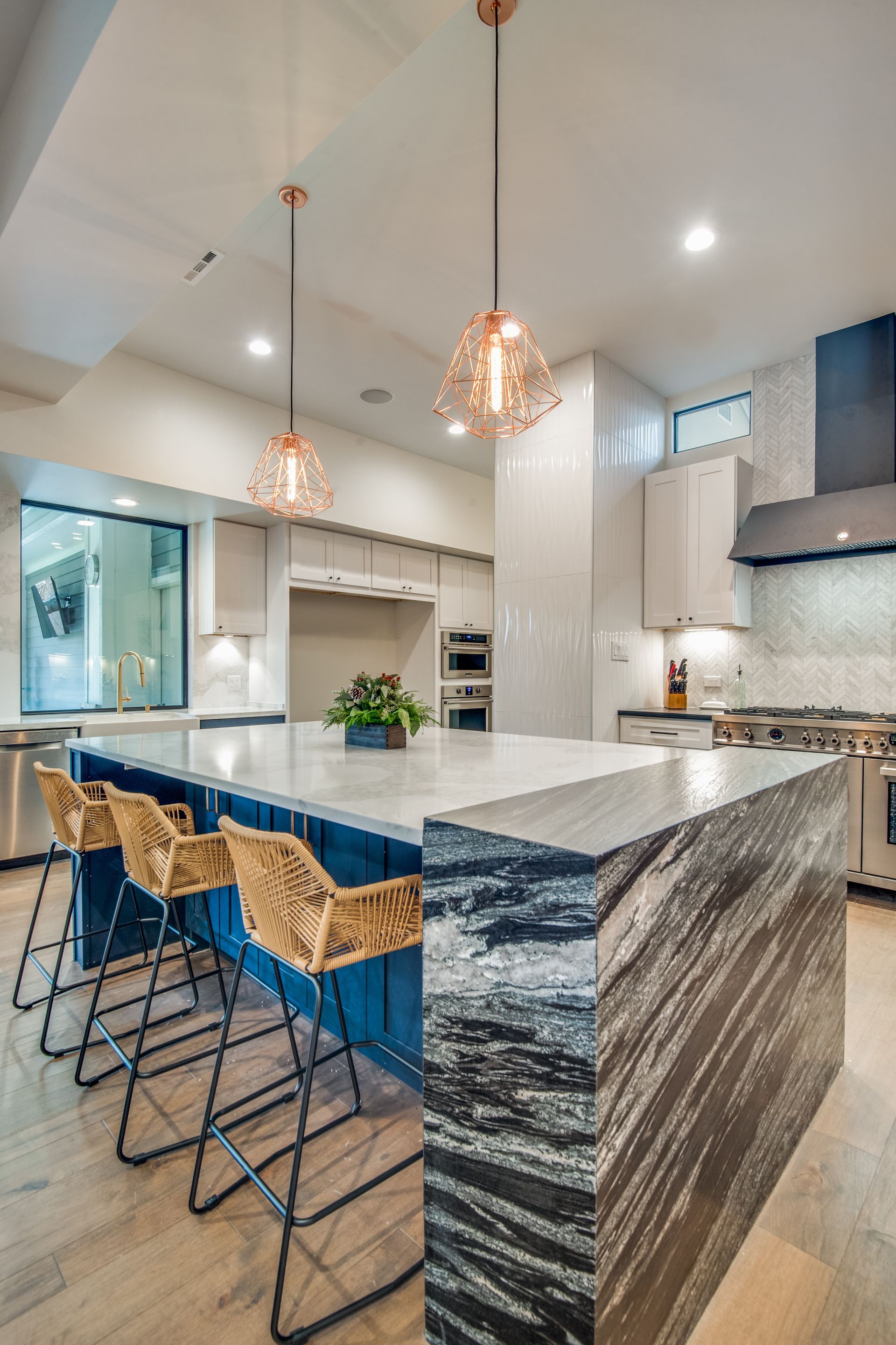 A kitchen with a large island and stools.