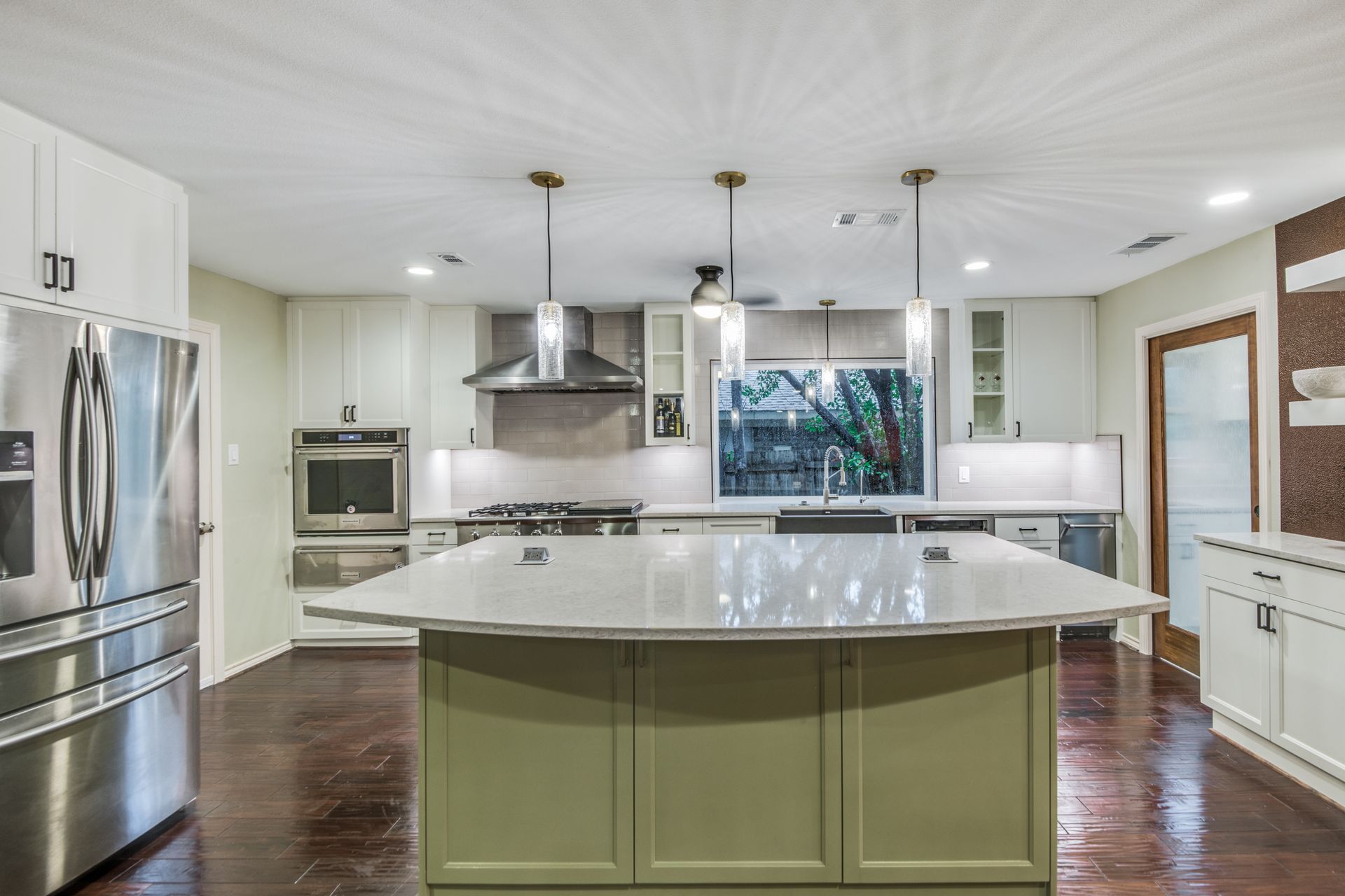 A kitchen with stainless steel appliances and a large island.