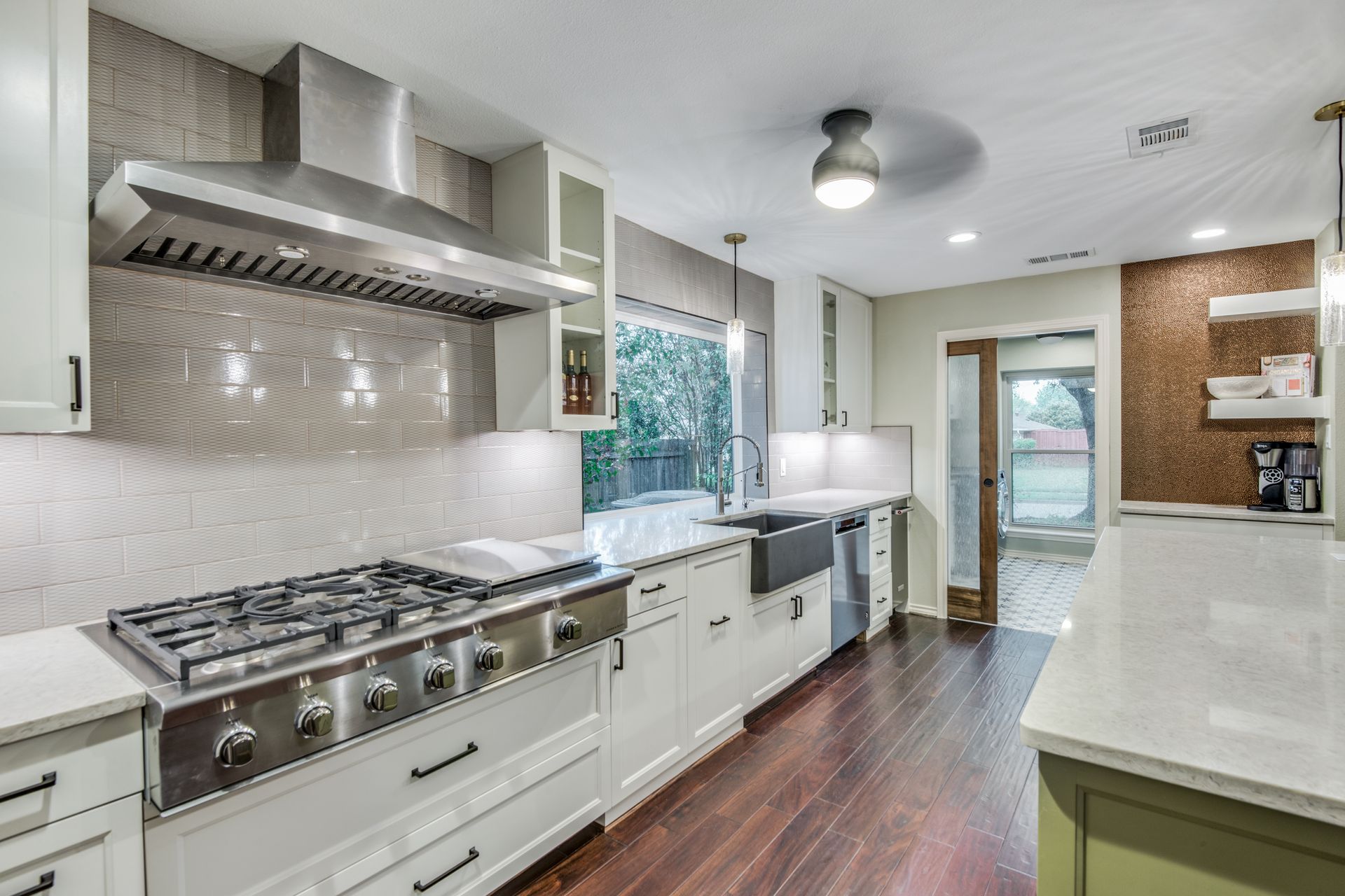 A kitchen with stainless steel appliances and white cabinets.