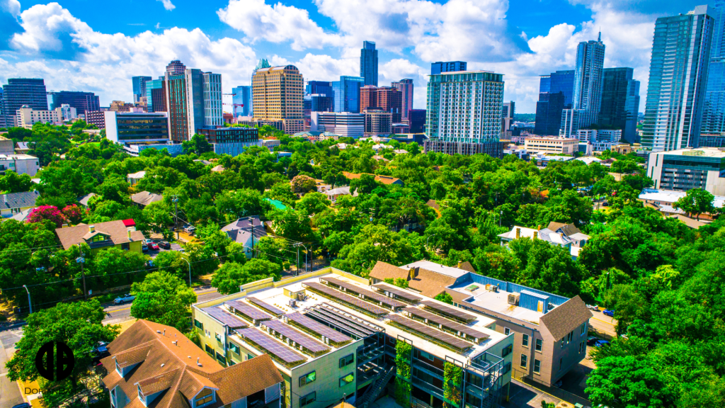 An aerial view of a city with a lot of trees and buildings in the foreground.