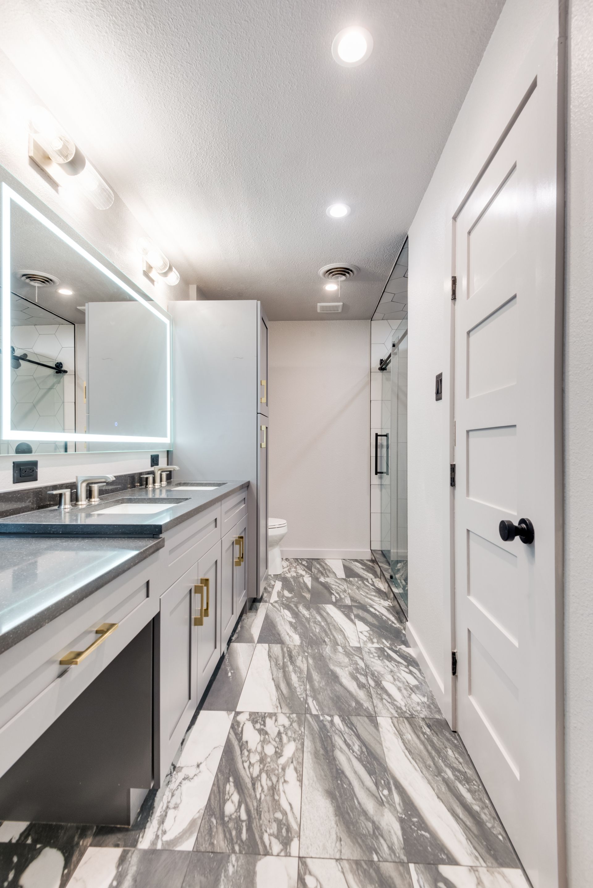 A bathroom with two sinks and a large mirror