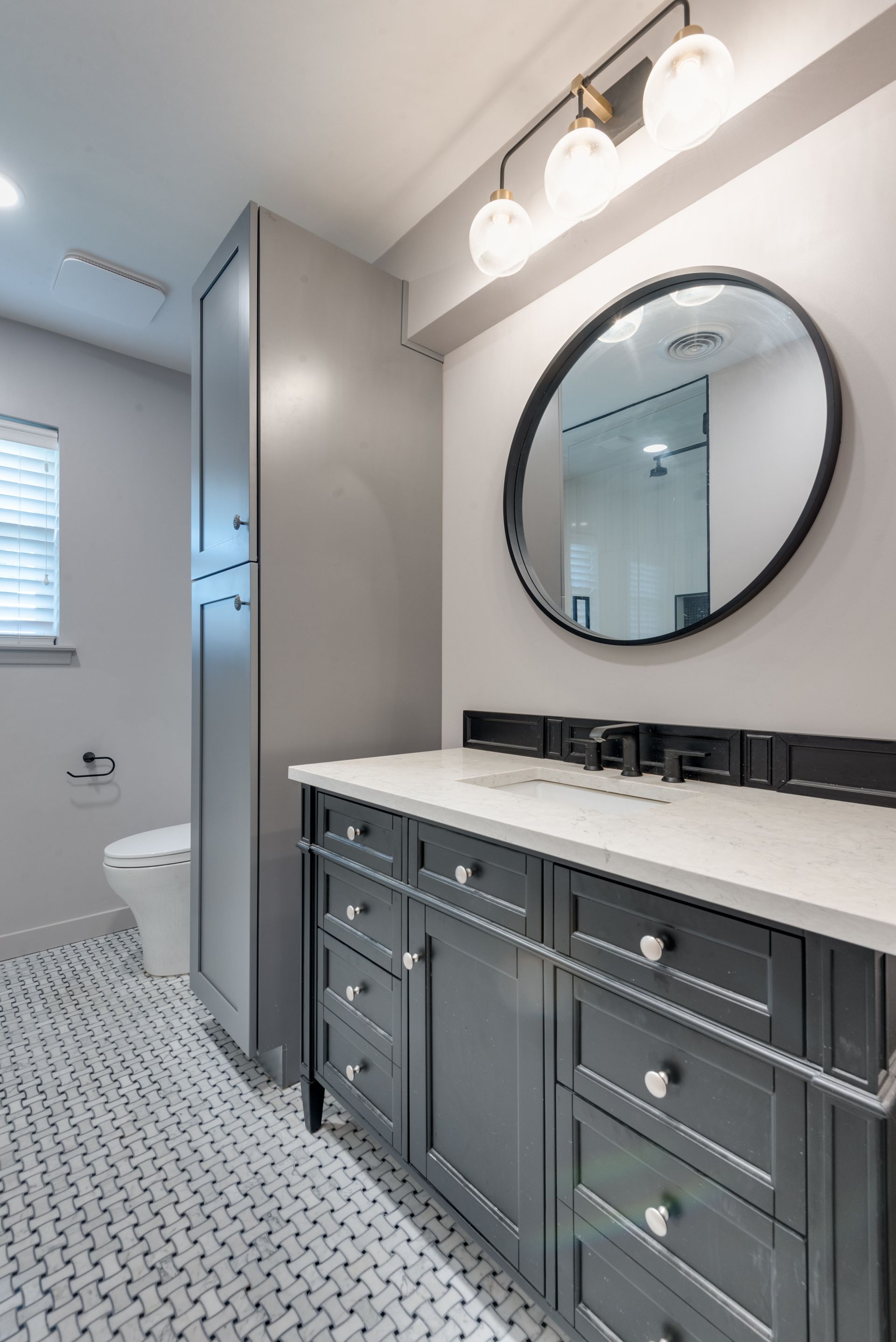 A bathroom with a sink , mirror and toilet.