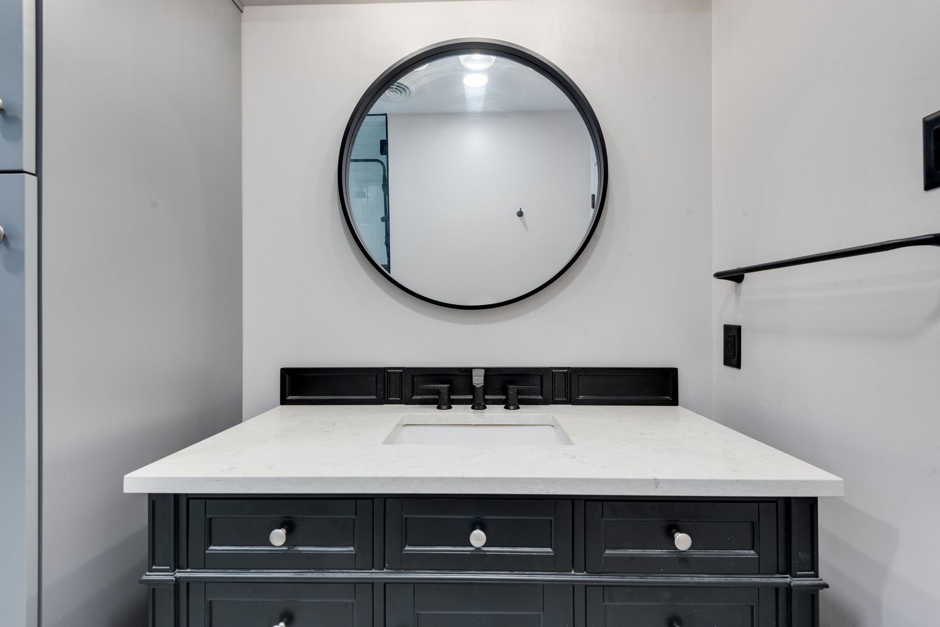 A bathroom with a sink and a mirror on the wall.