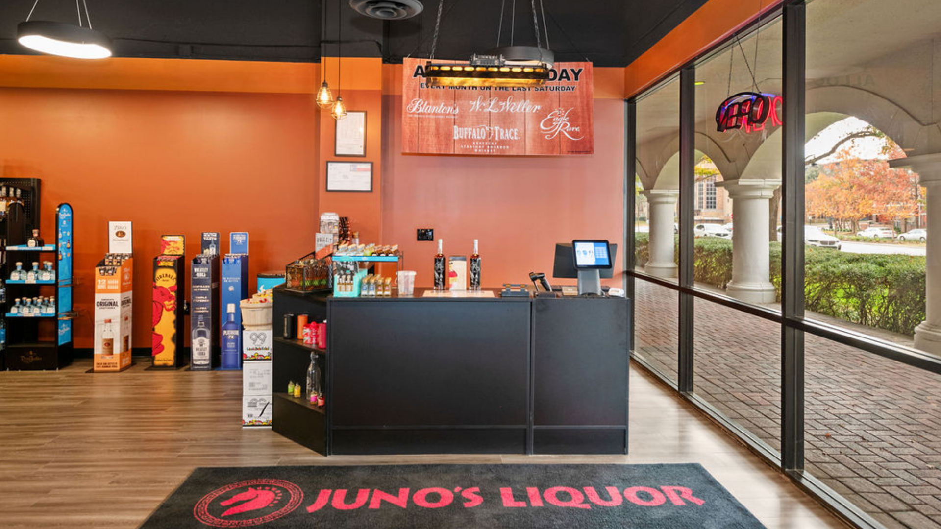 A liquor store with a black counter and a rug that says juno 's liquor