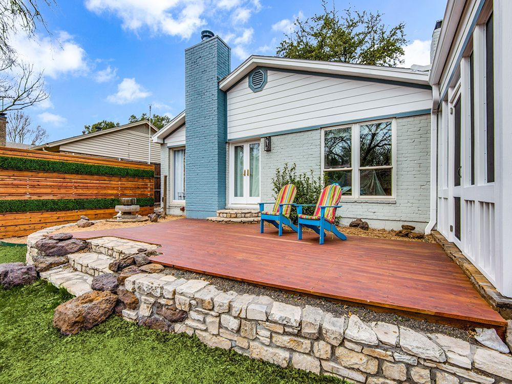 There are two chairs on the deck in front of the house remodel .