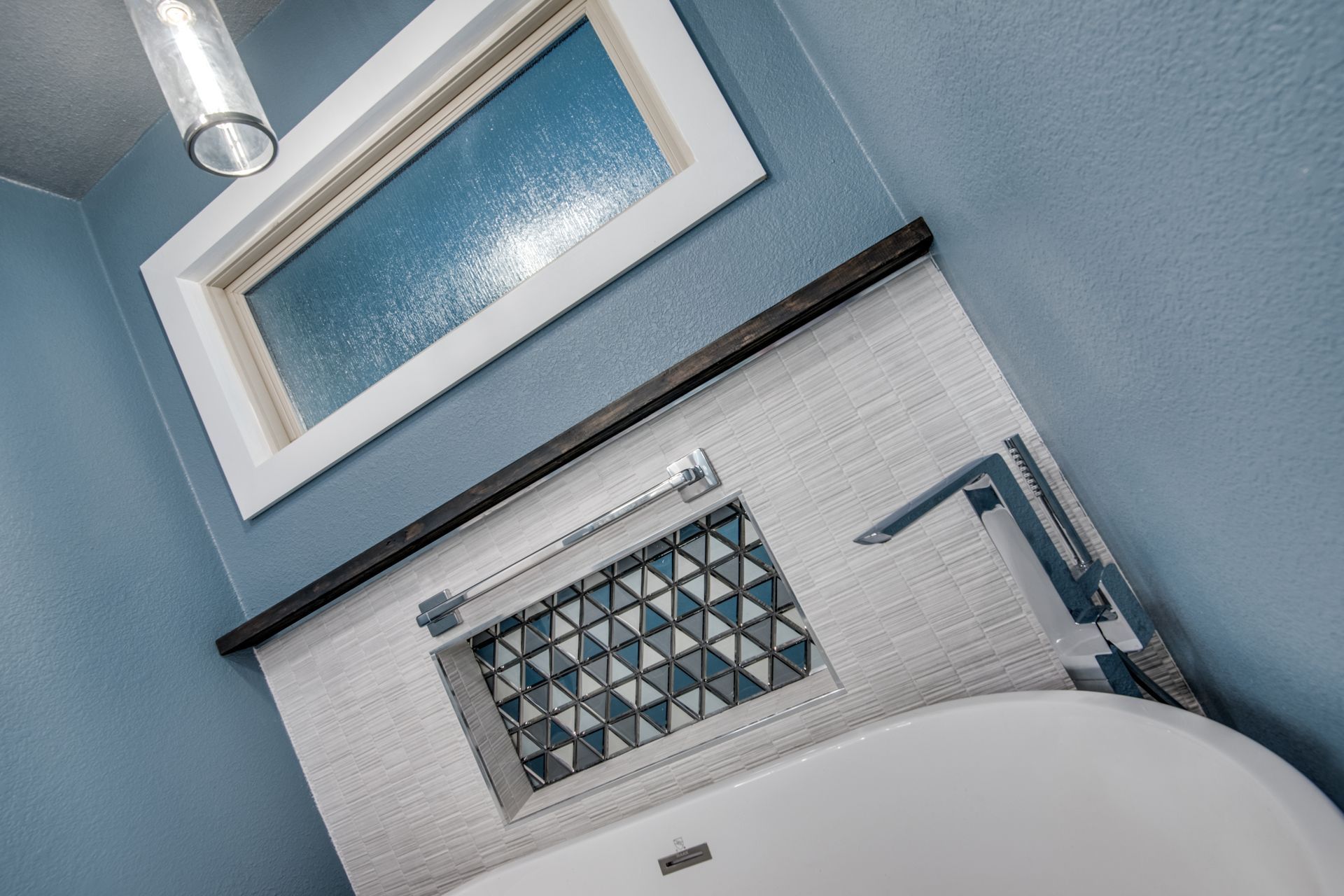 A bathroom remodel with a bathtub and a window above it.