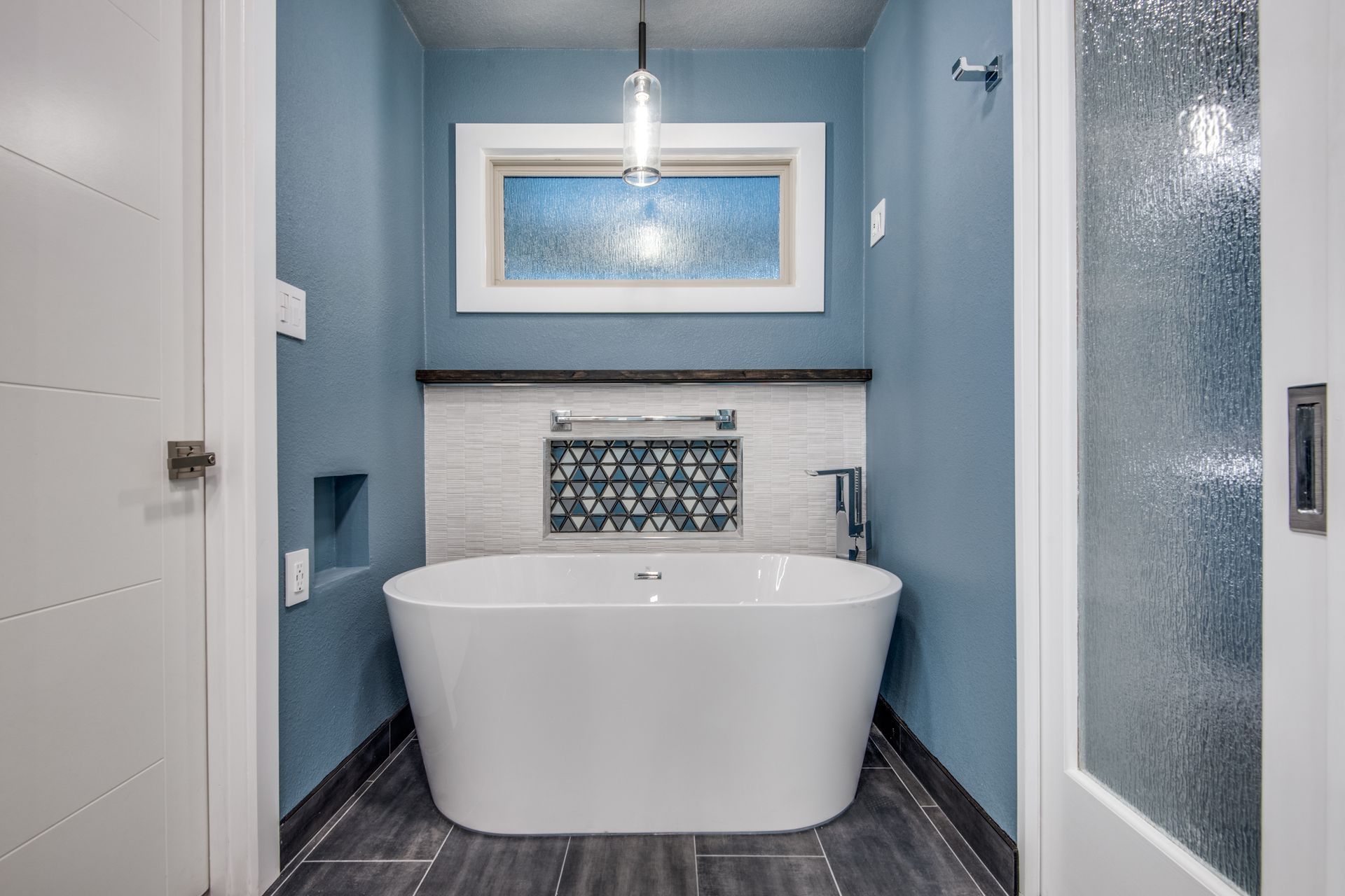 A bathroom remodel with a bathtub and a window.