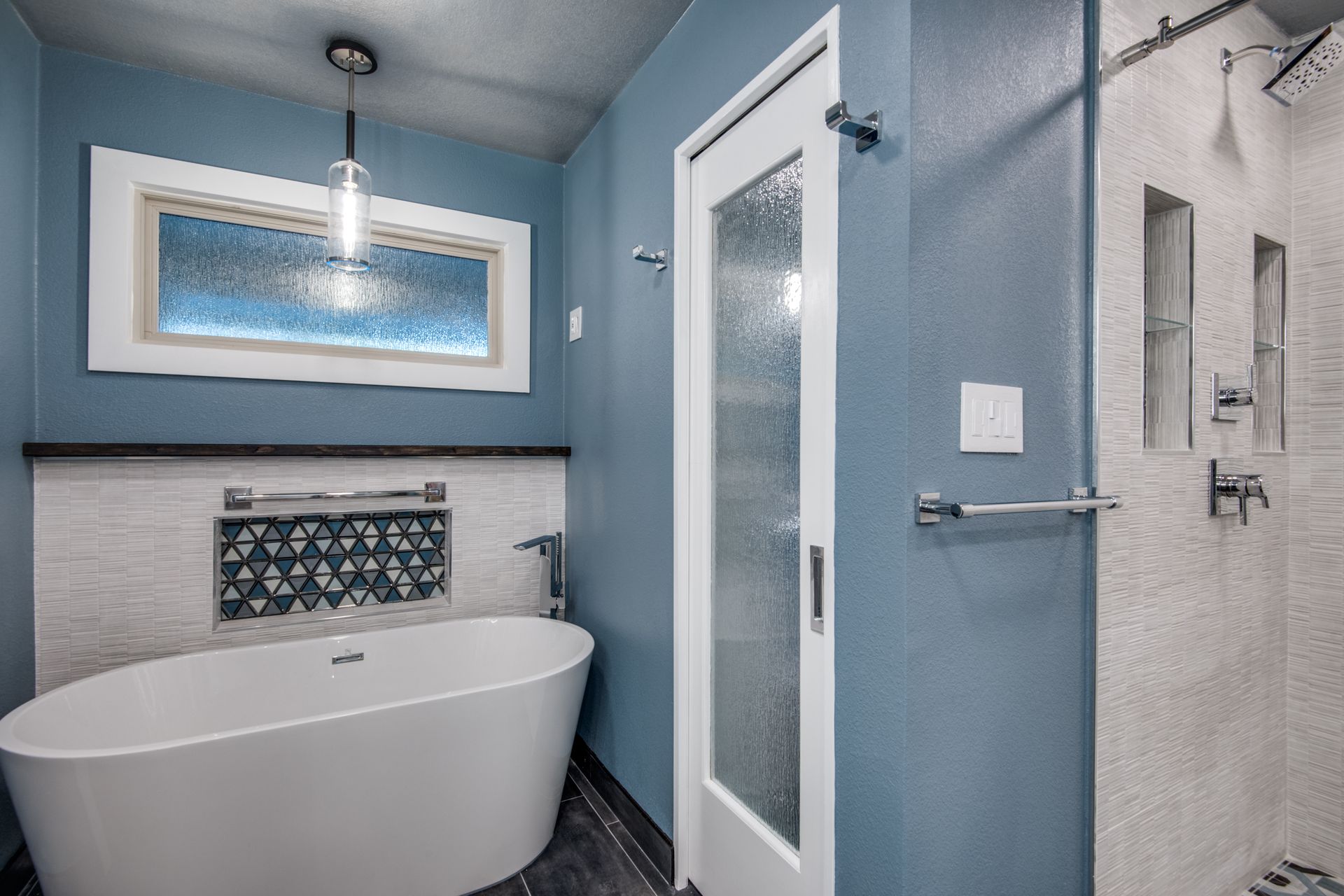 A bathroom with a tub , shower , and window.