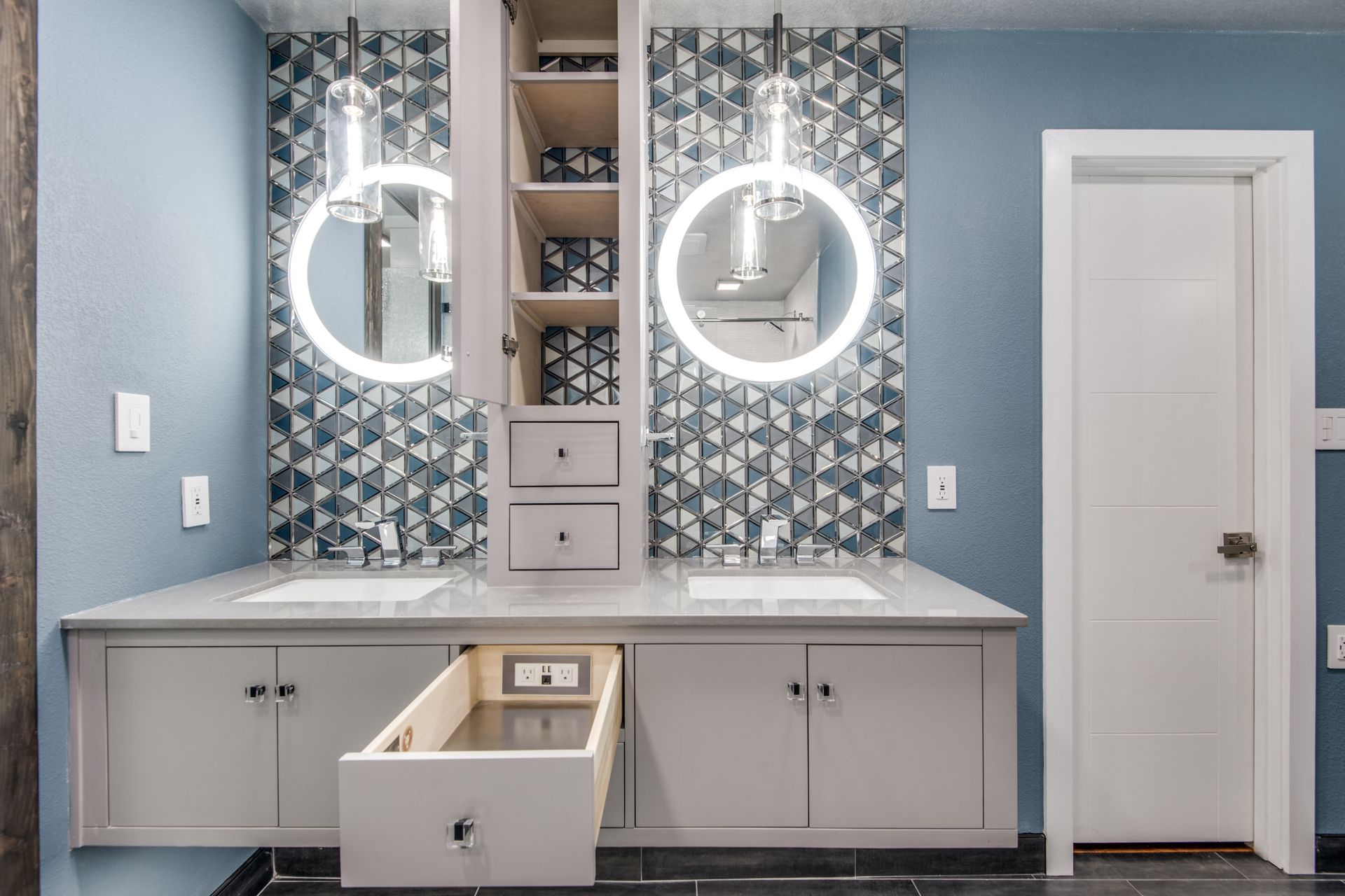 A bathroom remodel with two sinks , two mirrors and a drawer open.