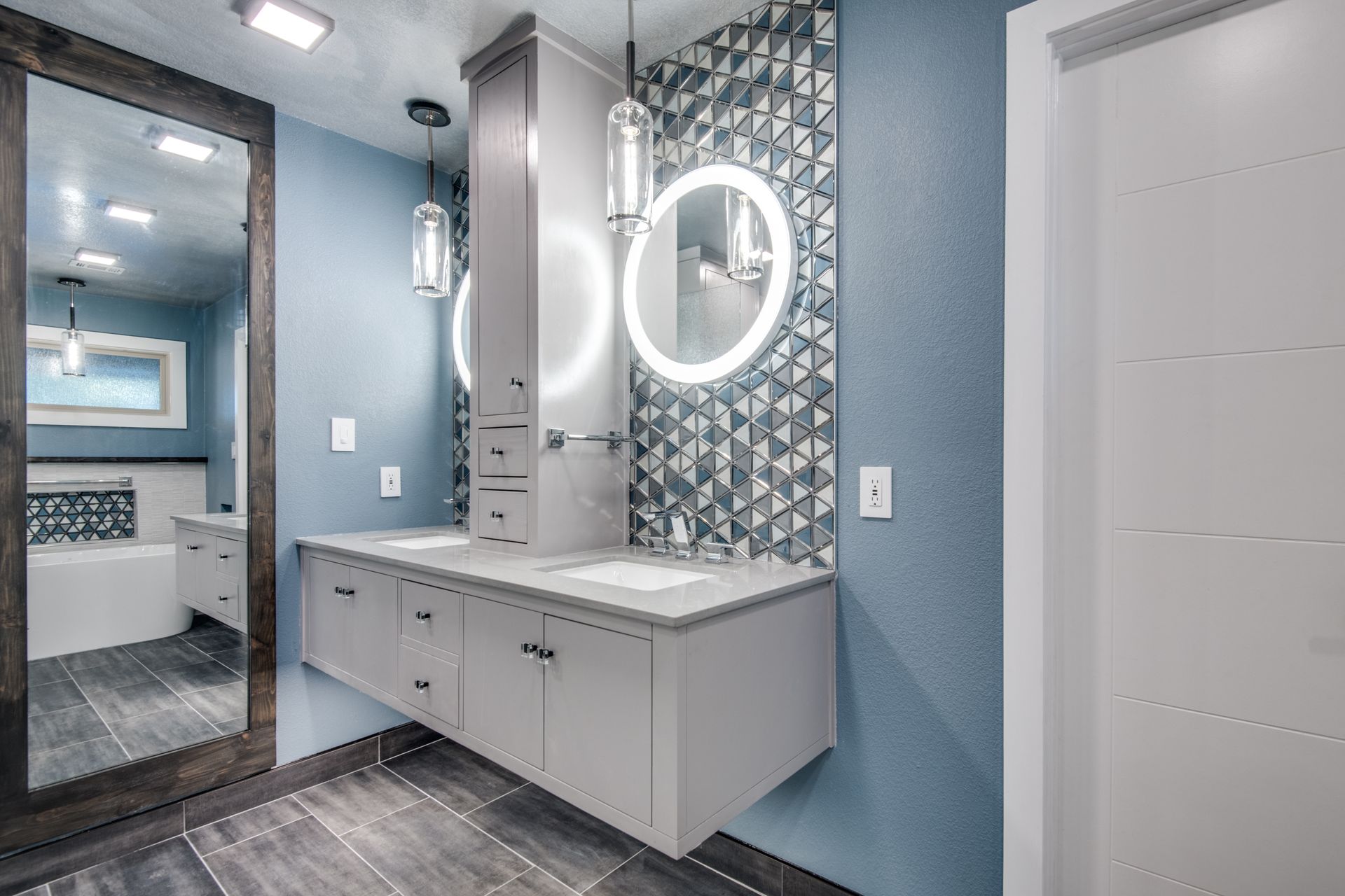 A bathroom remodel with two sinks and a large mirror.