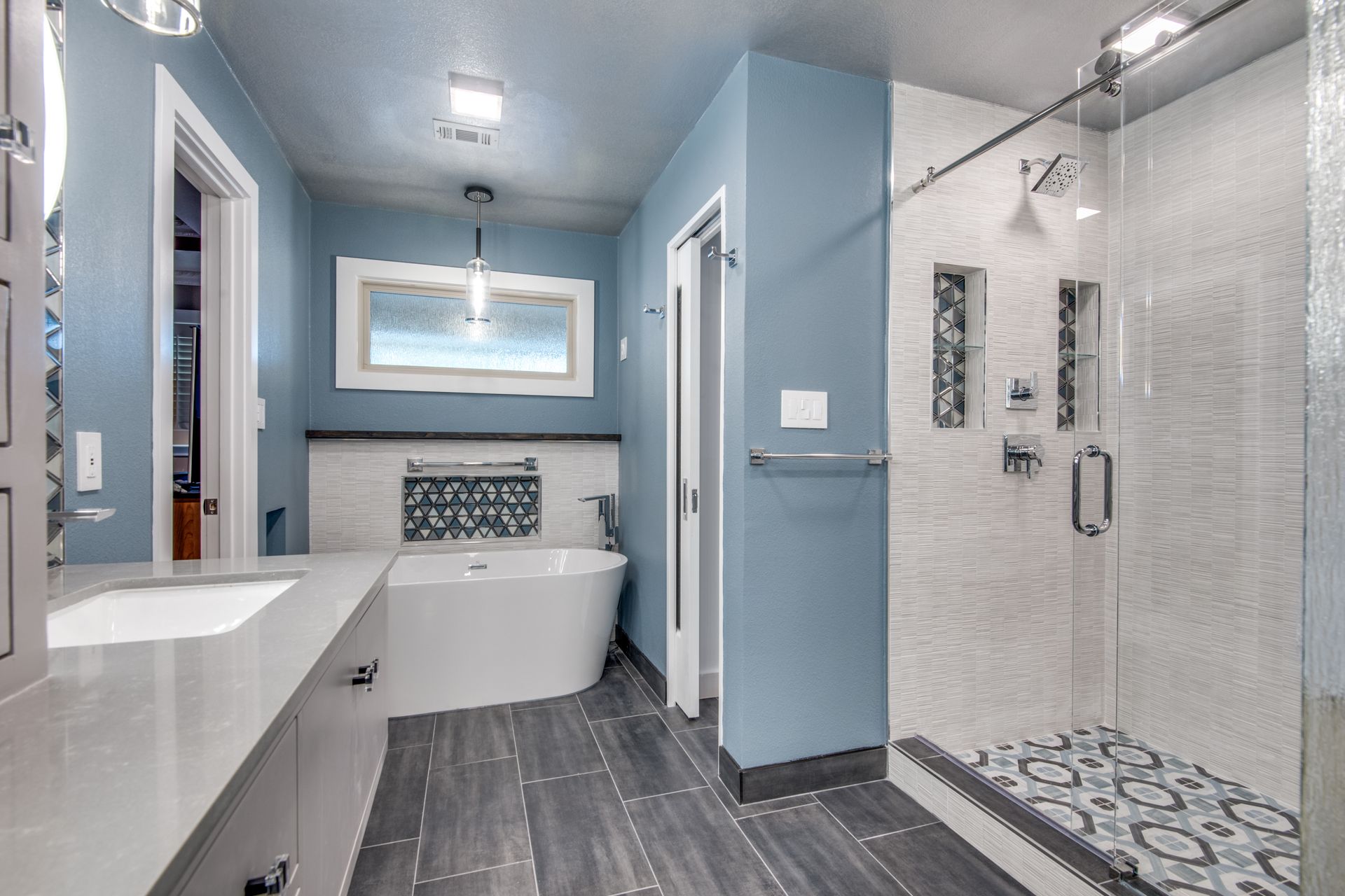 A bathroom remodel with a tub , sink , and walk in shower.