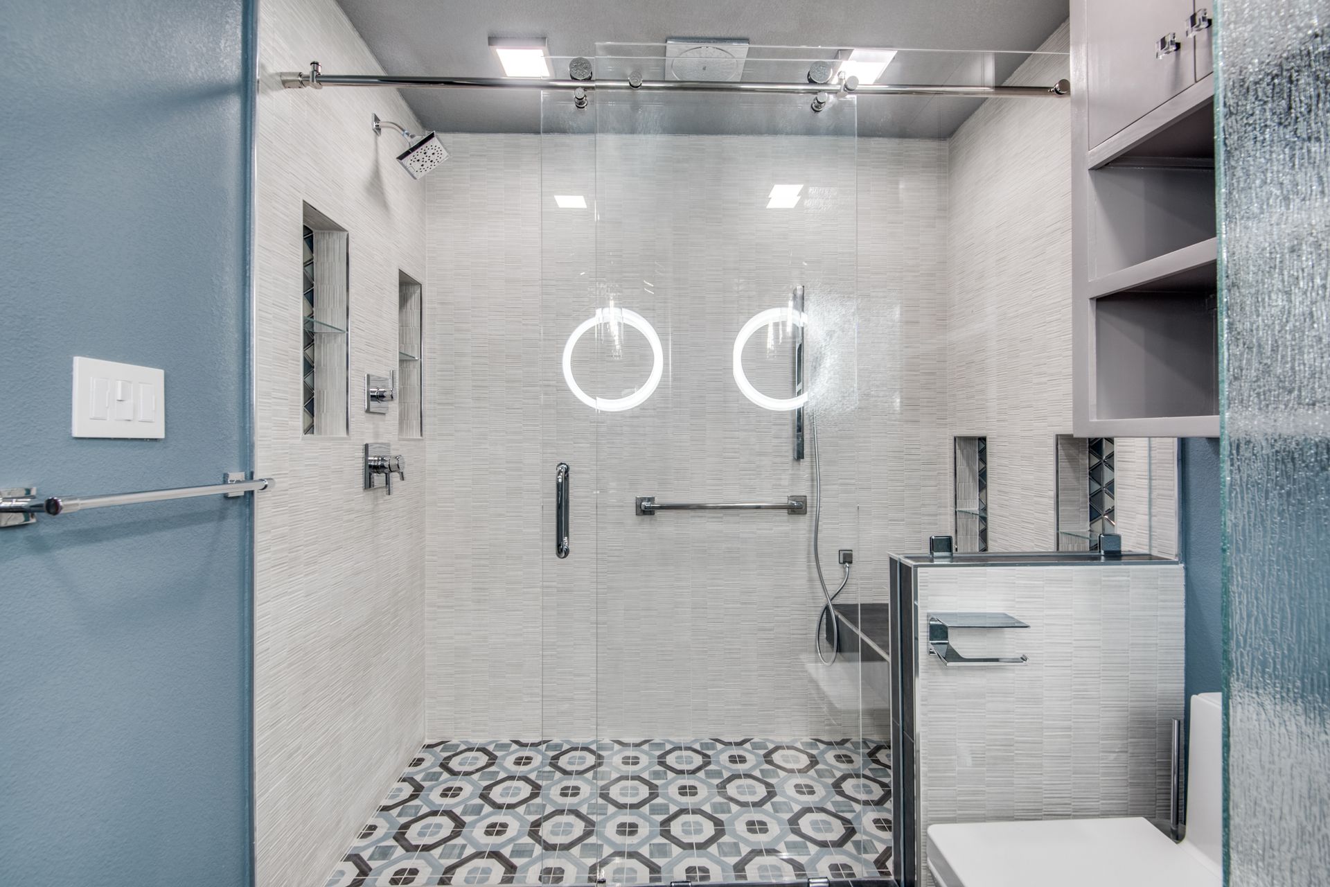 A bathroom remodel with a walk in shower and a toilet.