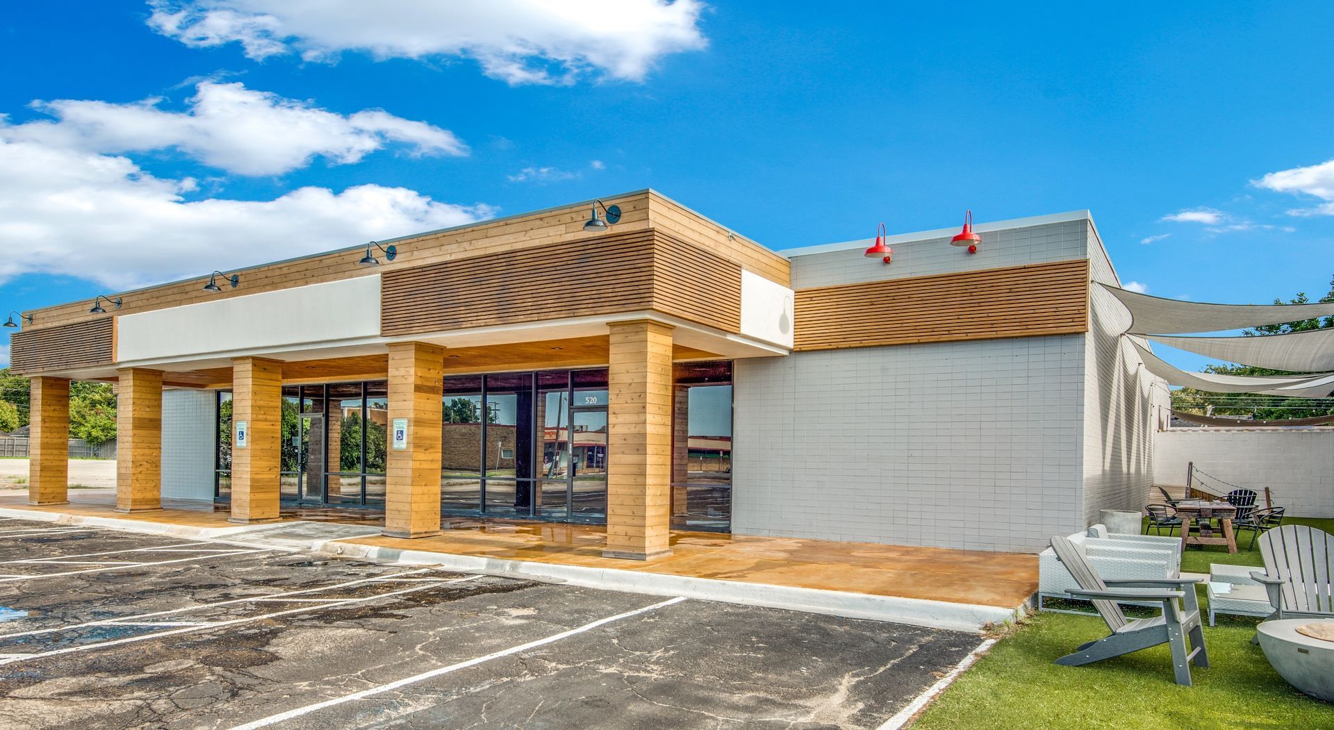 A large white building with a lot of windows and a picnic table in front of it.