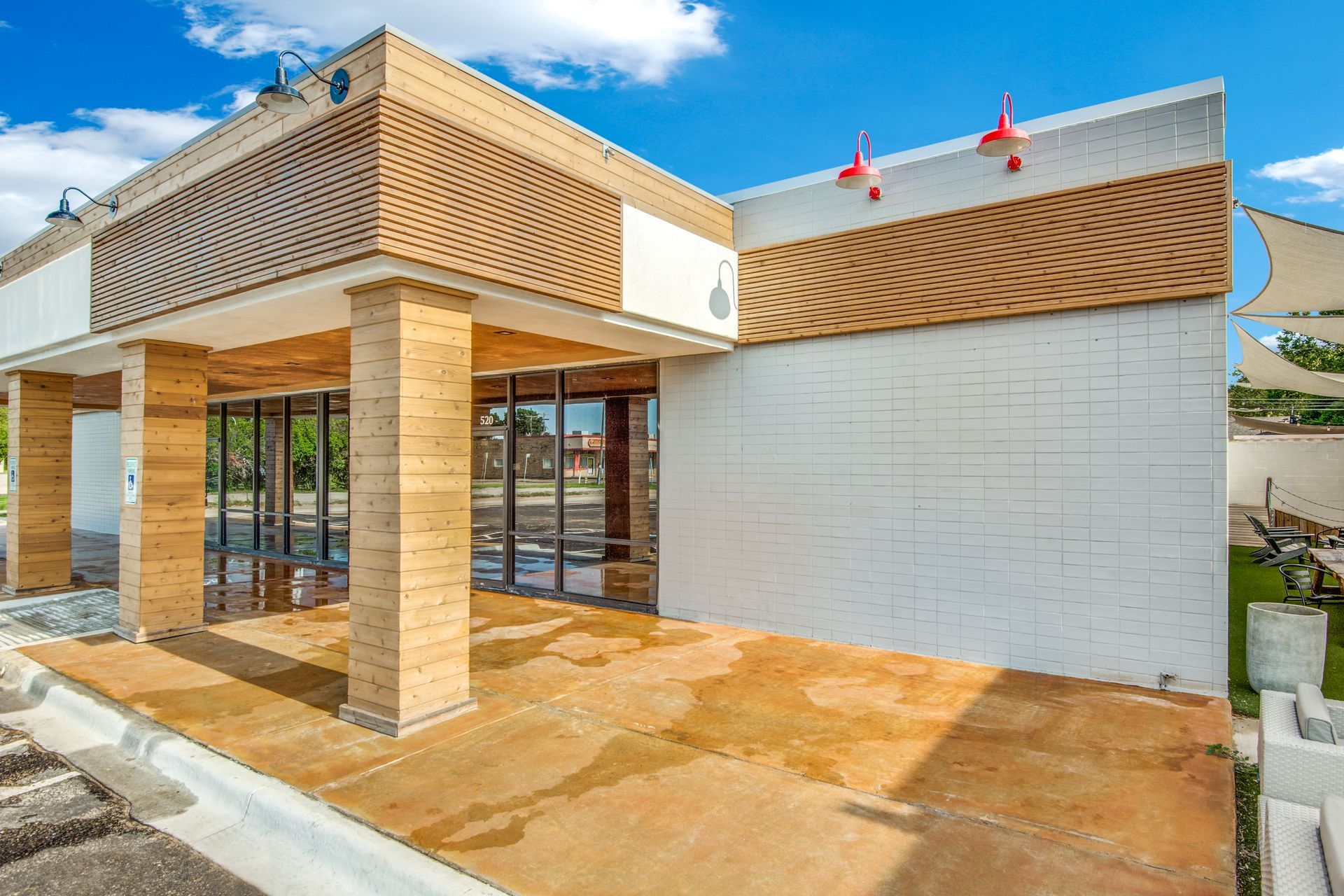 A white building with wooden pillars and a lot of windows.