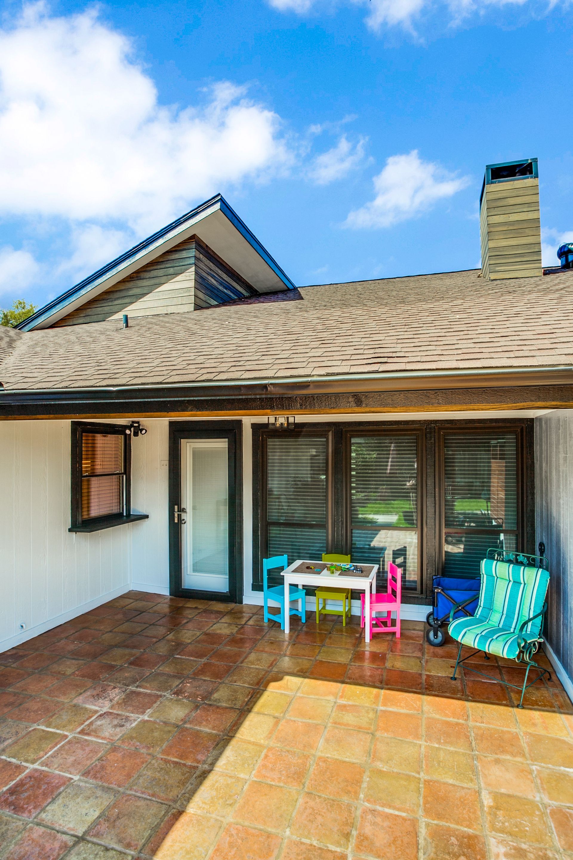 A patio with a table and chairs in front of a house.