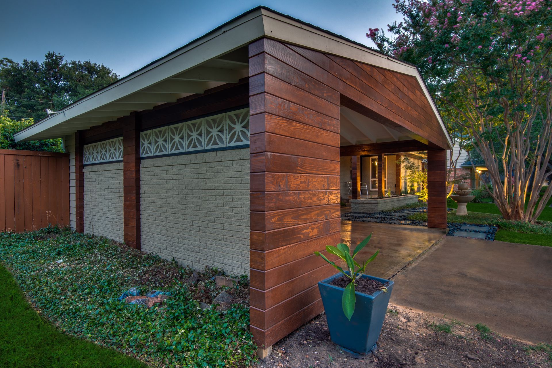 A brick garage with a potted plant in front of it.
