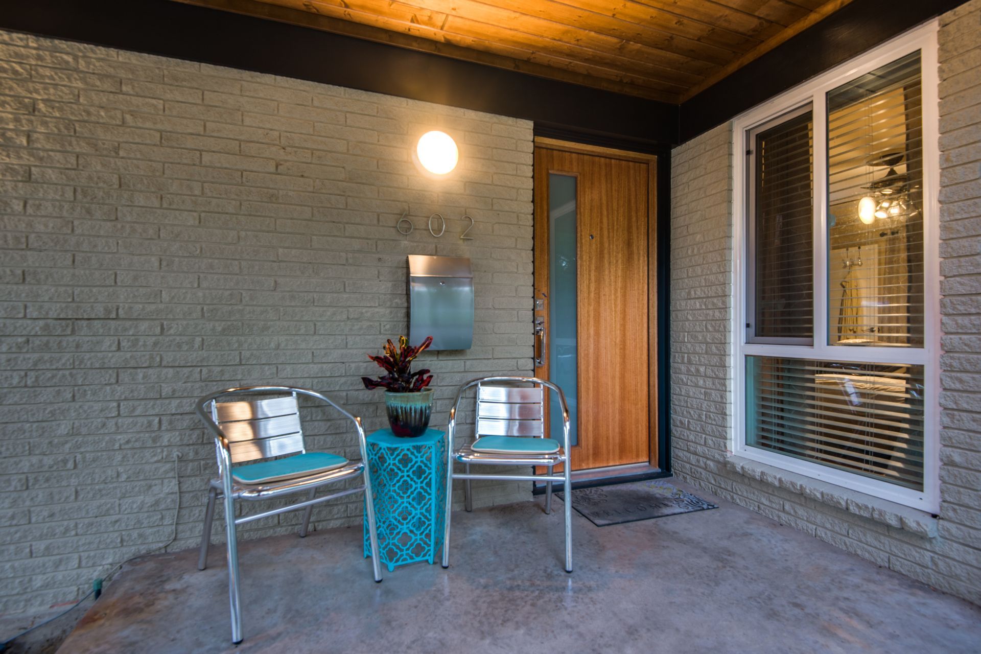 The front porch of a house with two chairs and a table