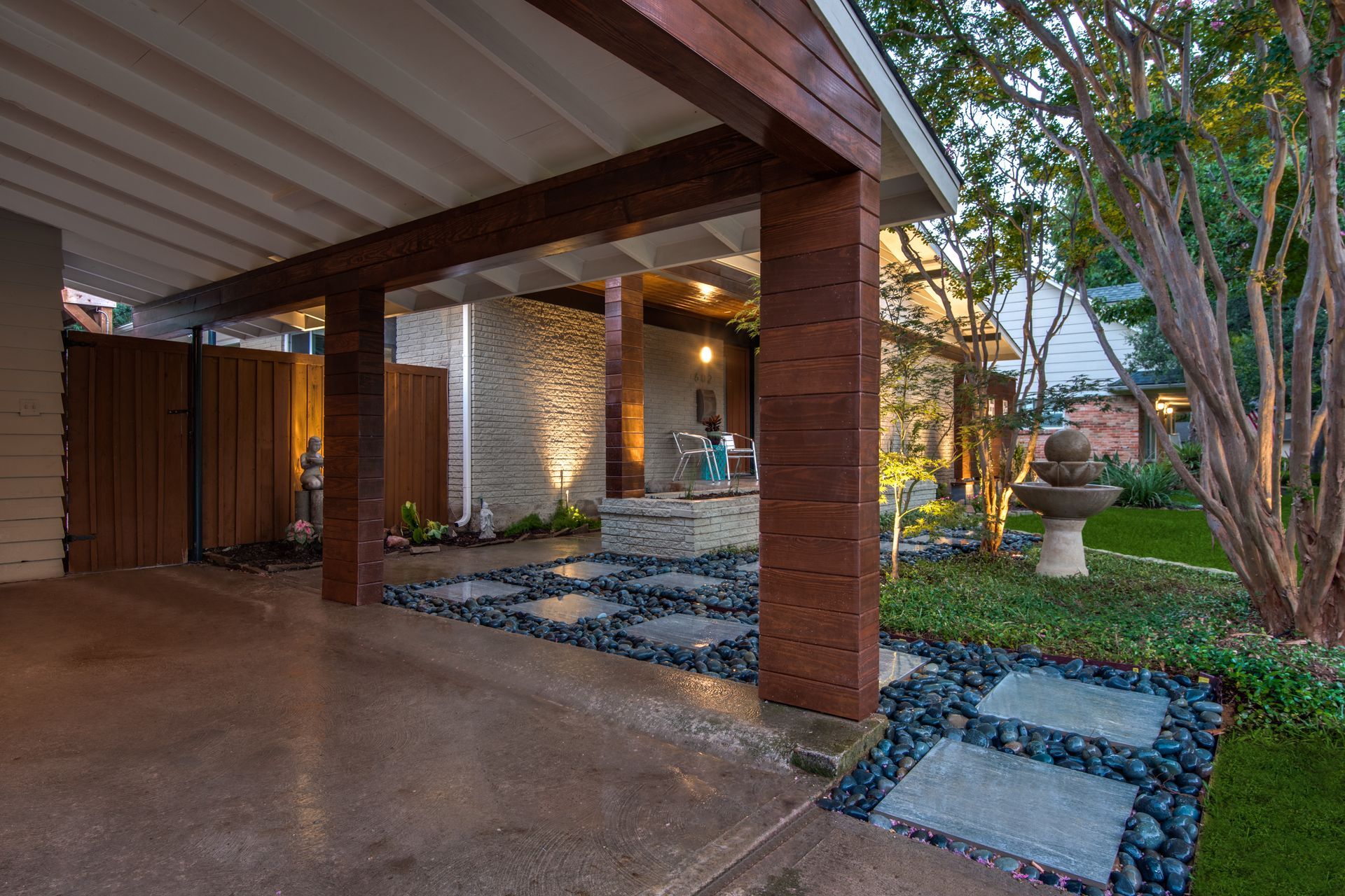 A house remodel with a covered driveway and a walkway leading to it.
