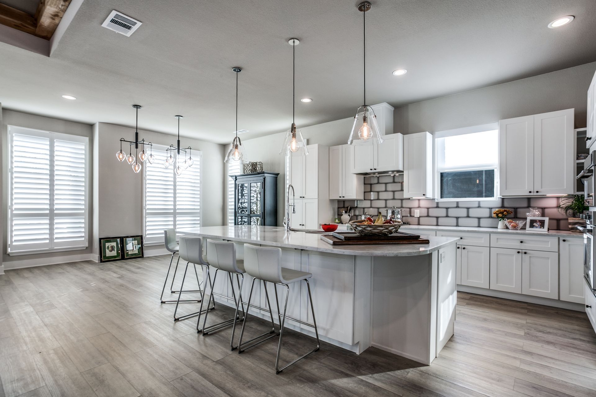 A kitchen with white cabinets and a large island in the middle.