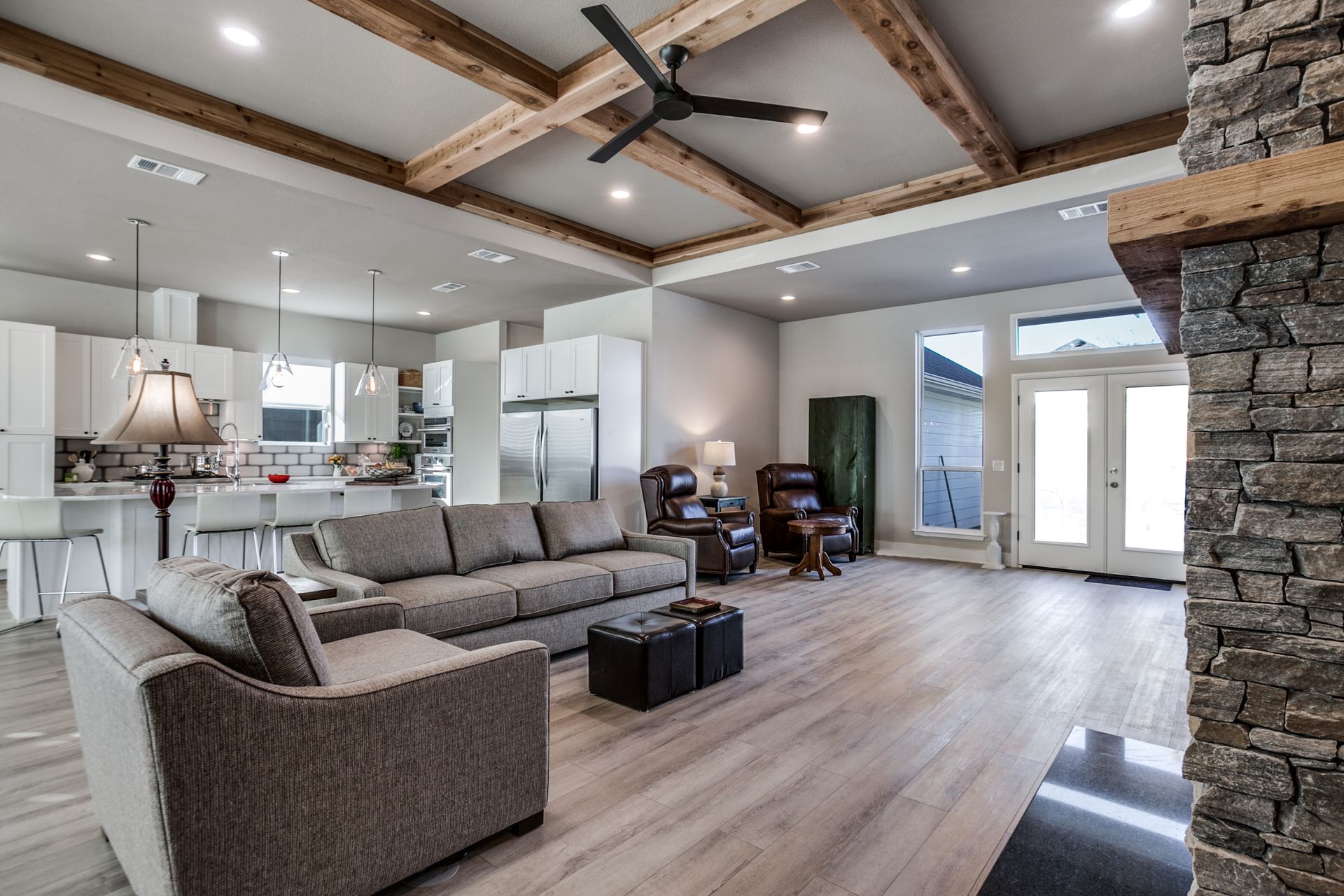 A living room with a couch , chairs , and a ceiling fan.