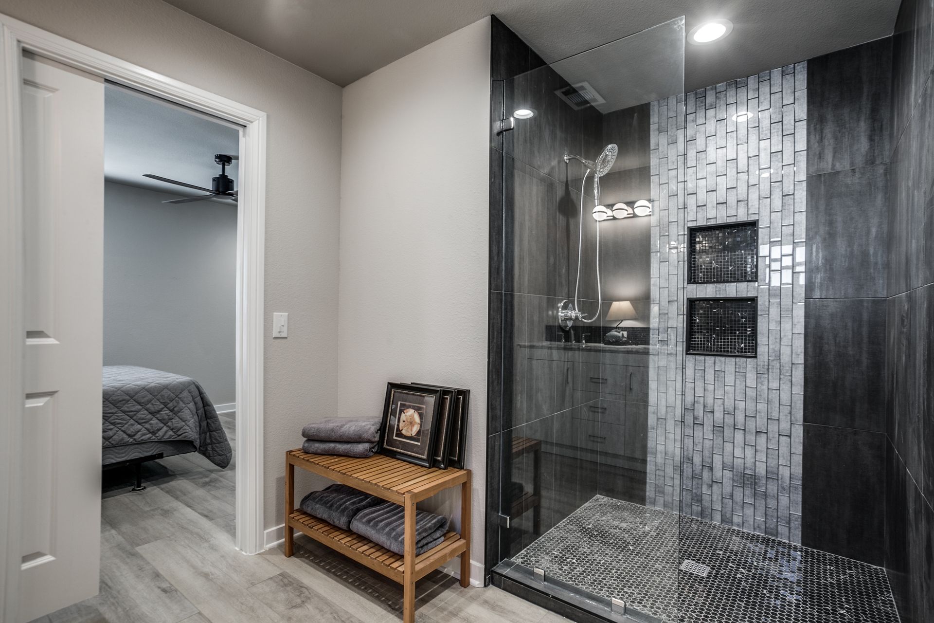 A bathroom with a walk in shower and a bench.