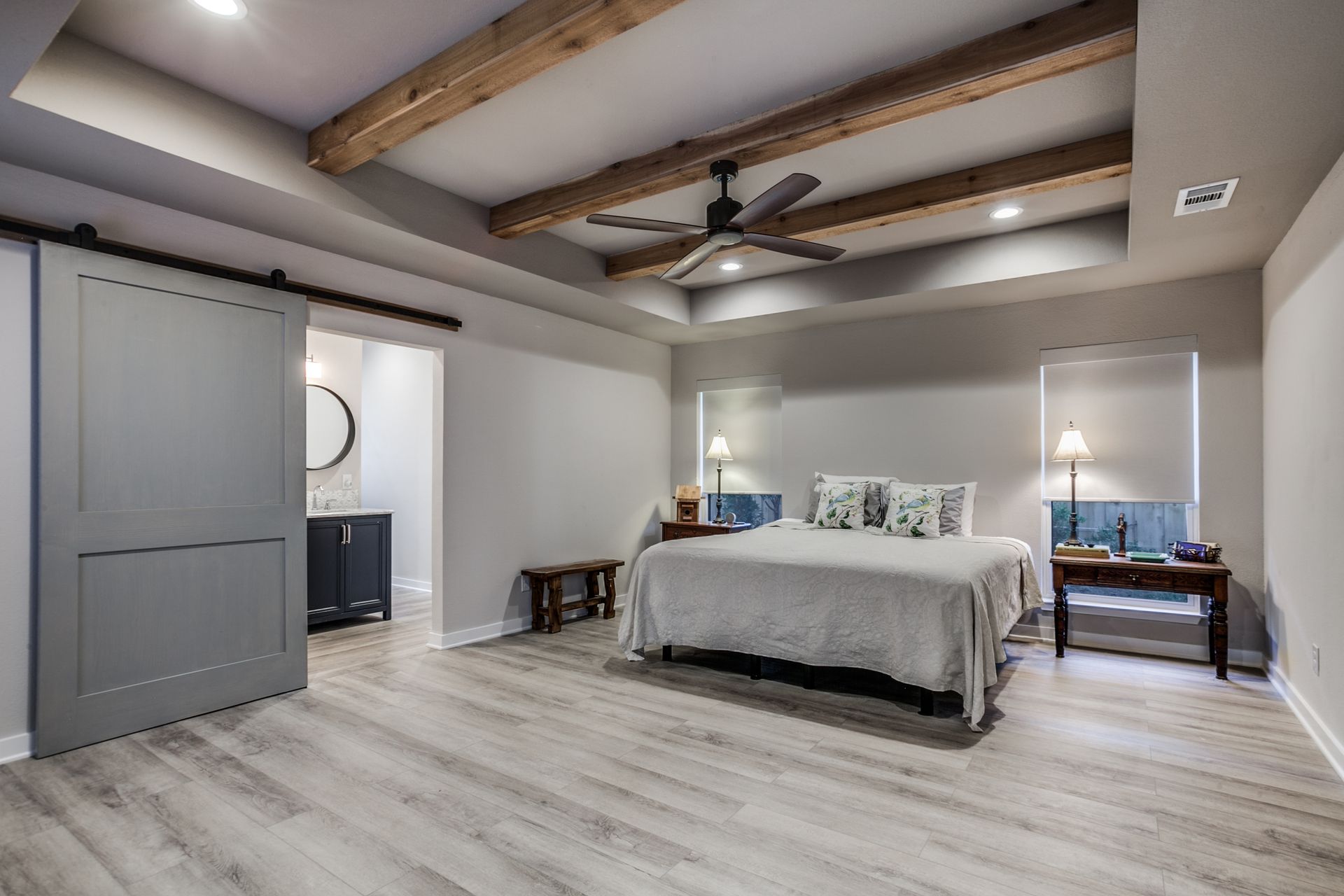 A bedroom with a king size bed and a ceiling fan.